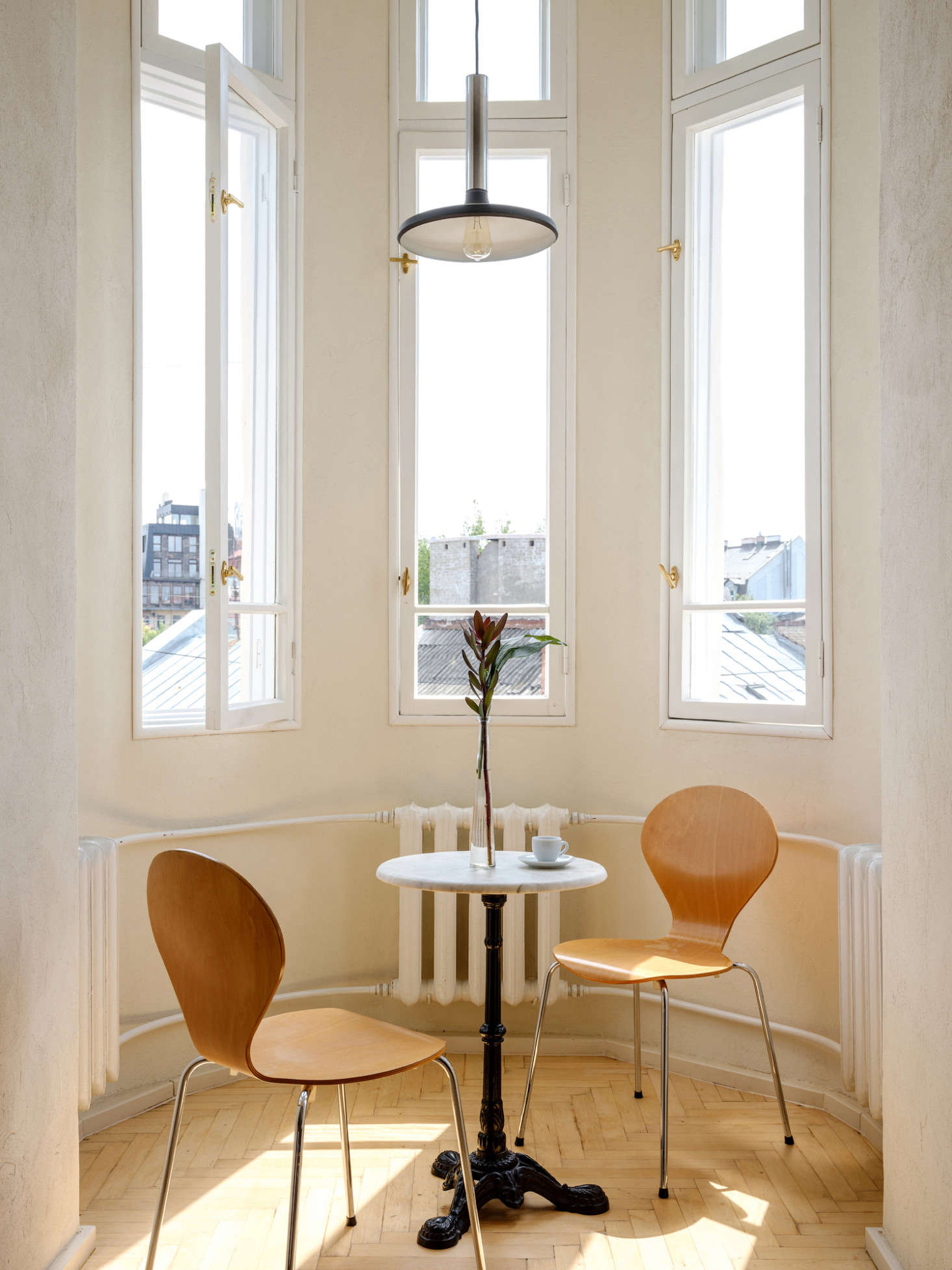 The apartment is set on the top floor of an early 20th century building with a turret that serves as the dining room. Wilkins has since replaced the cafe table with a bigger one. He brought the hanging light and chairs from Berlin. The wall-hung radiators are original to the apartment: Dervish had them removed, sandblasted, and repainted.