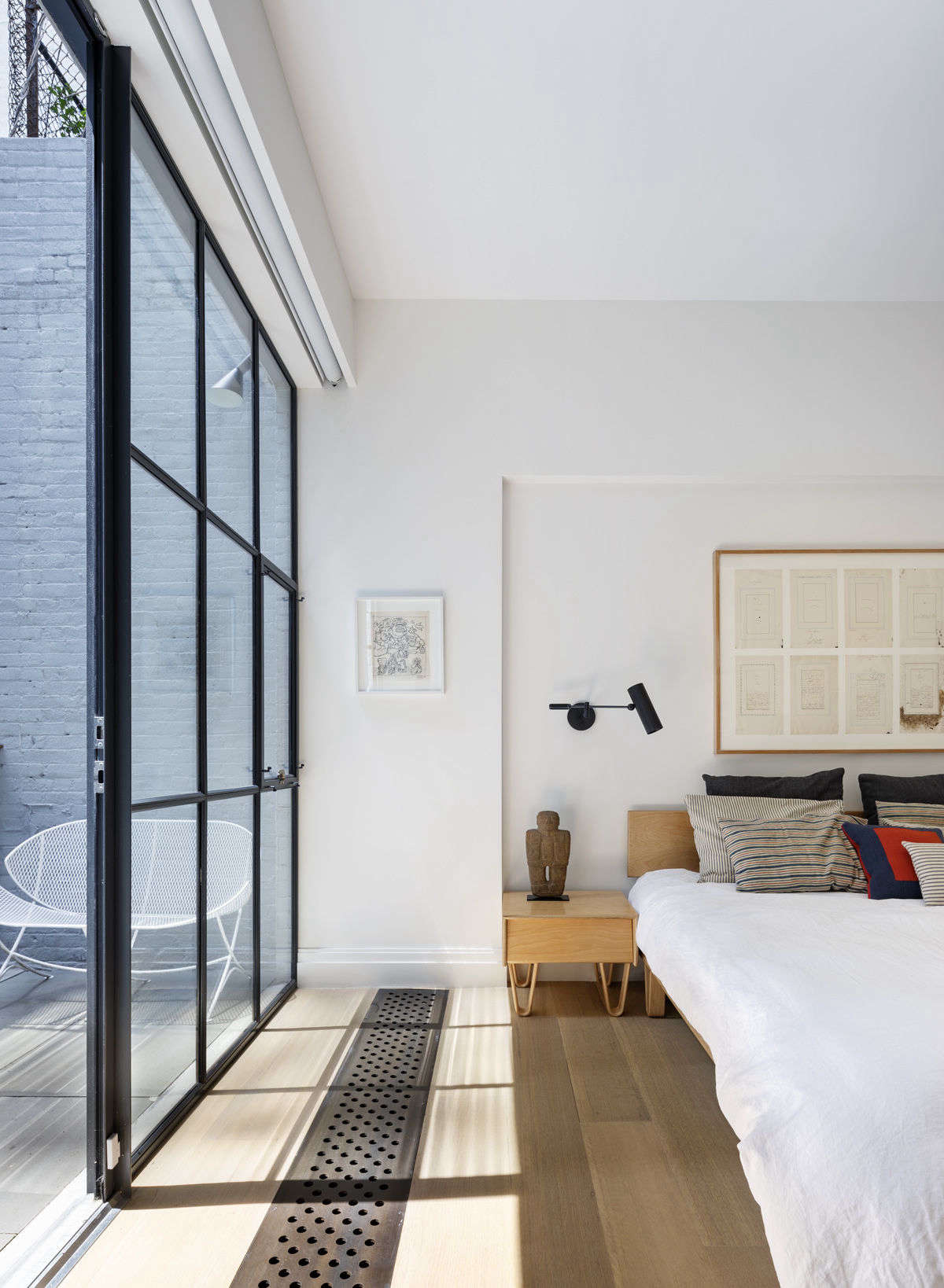 The master bedroom features floor-to-ceiling windows and access to a small deck that overlooks the backyard. Note the niftily hidden blinds.