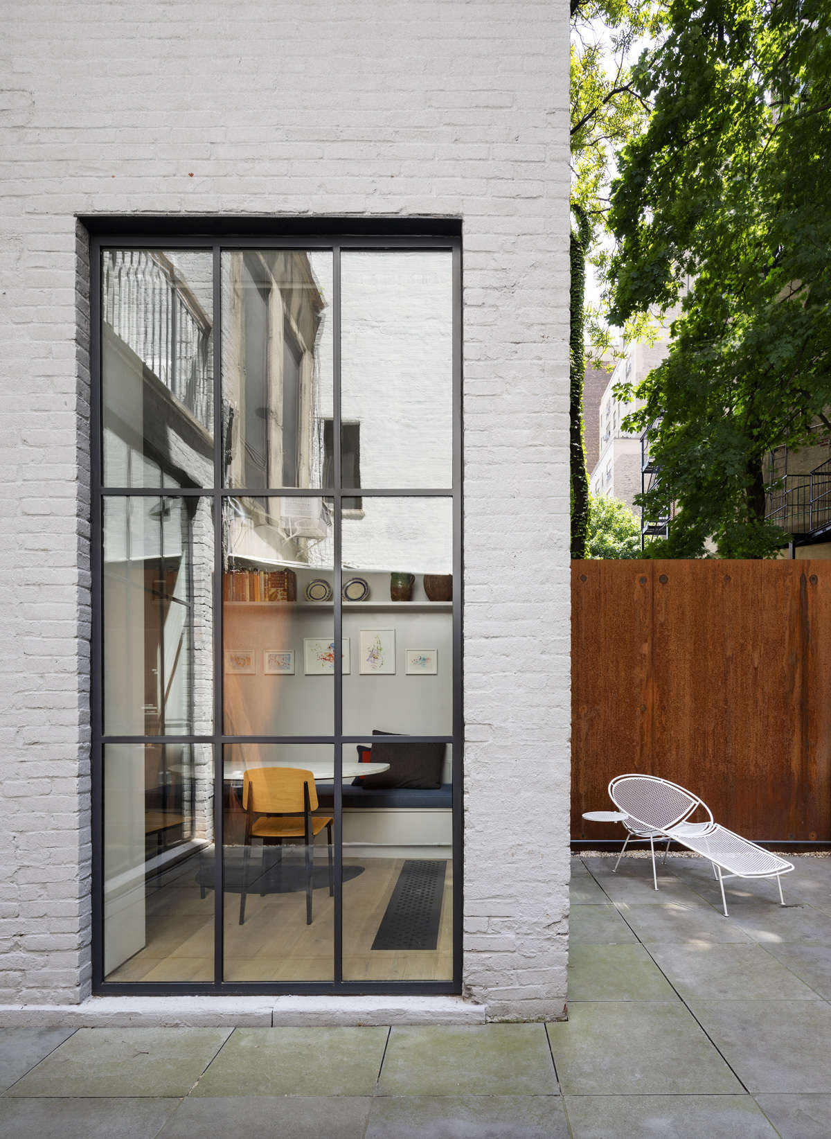 The view from the outside into the breakfast nook. The bluestone patio in the back offers another space to entertain guests.