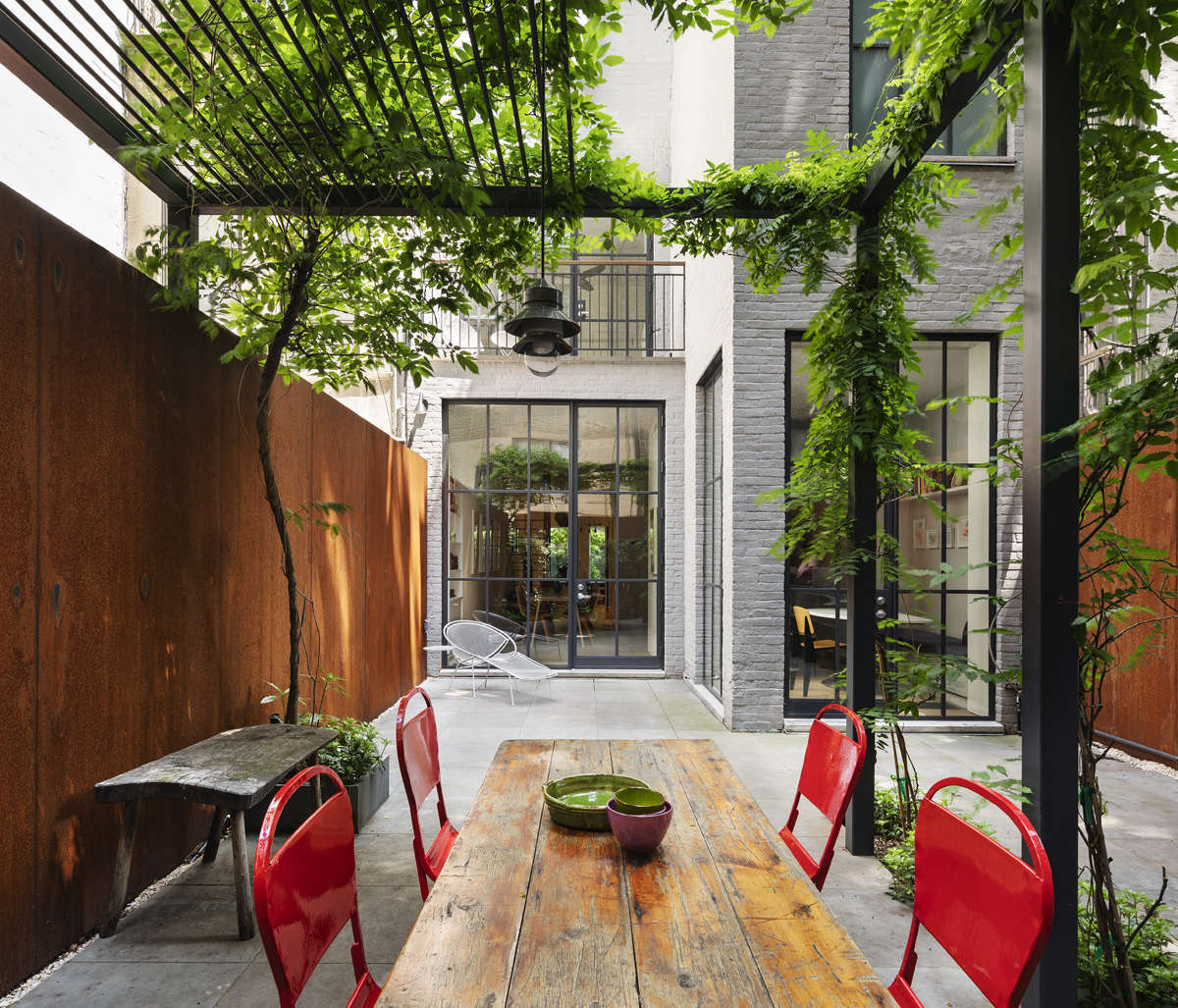 “We essentially built the garden around the wisteria,” O’Neill says, of the tree on the left. It’s the only plant they kept from the original backyard. The walls are made from sheets of corten steel, the same type of metal favored by artist Richard Serra. “Sam likes the way it weathers.”