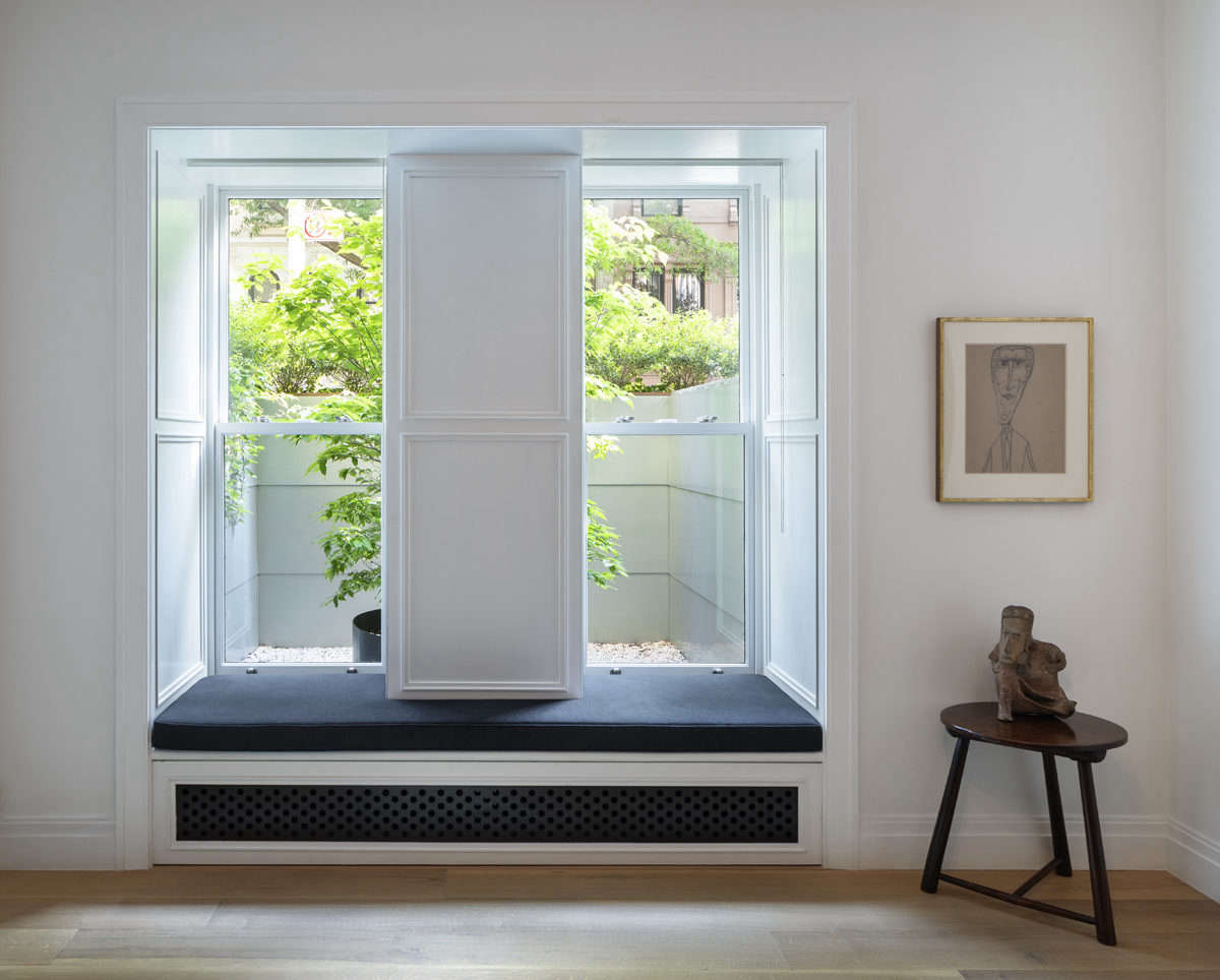 A window seat with a view. Street-side zinc planters and a potted dogwood tree provide privacy.
