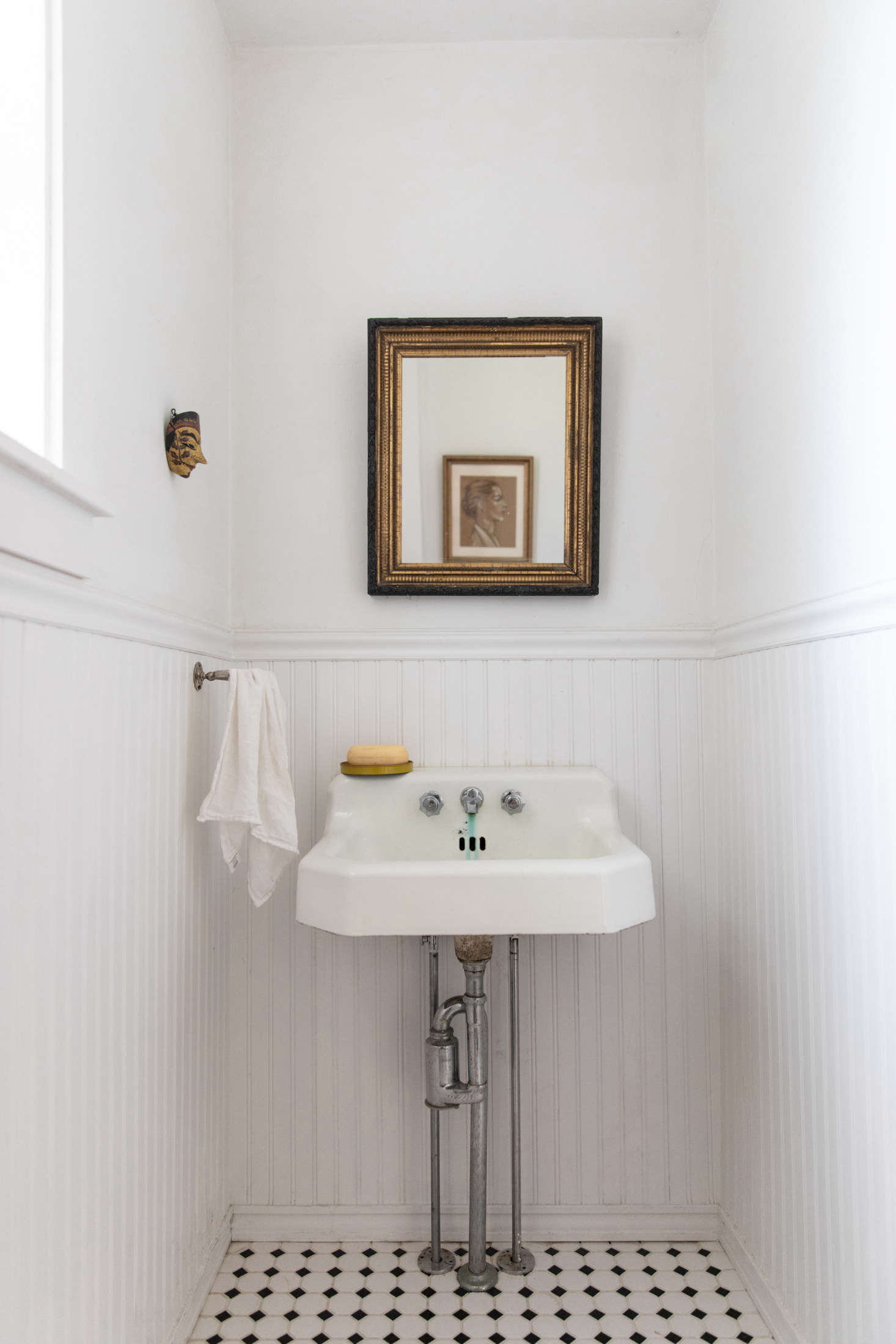 One of two bathrooms, with beadboard wainscoting and a well-loved sink. 