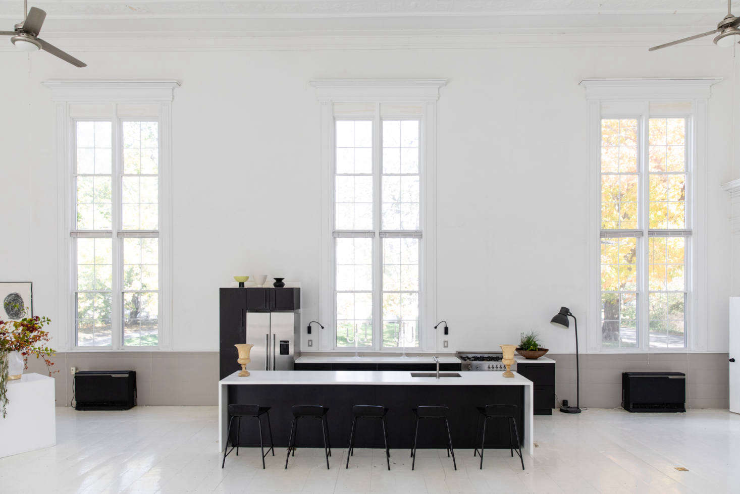 McNeil installed a kitchen in the center of the main space, framed by the windows. Though it looks like a high-end kitchen system, it