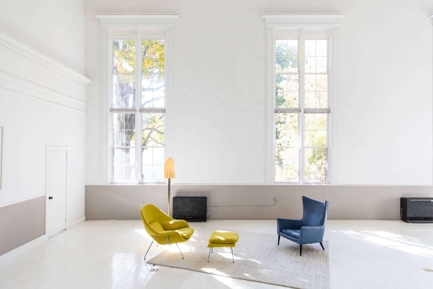 The deconstructed living area is set apart by a rug, and fitted with an Eero Saarinen Womb Chair (
