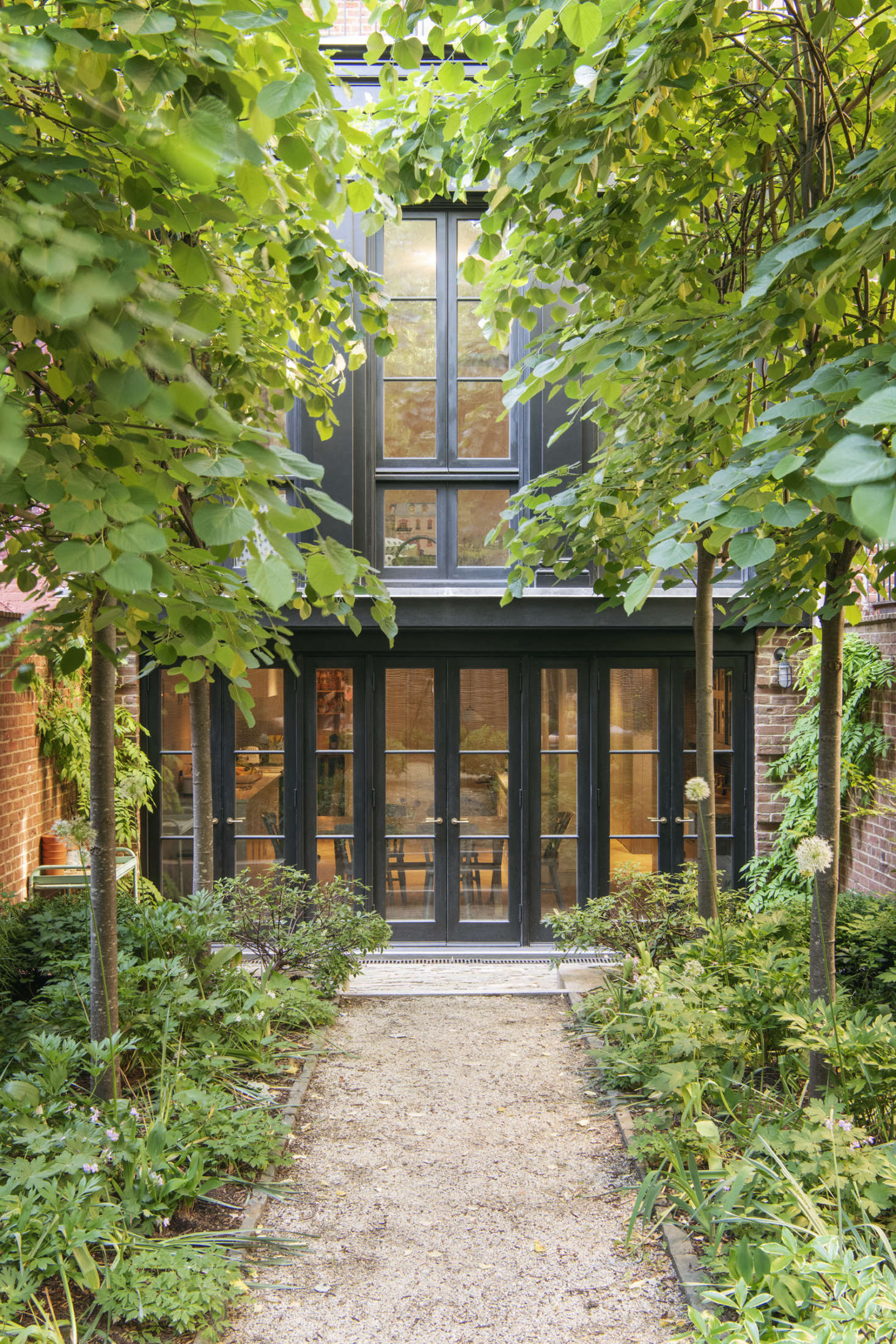 The house’s back addition was modeled after “the tea porch extensions often introduced to these brownstones in the 1850s,” says Lekwa. It replaced an existing dilapidated two-story addition, and, Lekwa notes, “is almost entirely window, but rather than do a huge sheet of glass, we articulated the garden floor with brick piers at the sides. We painted it black just like the old extension.”