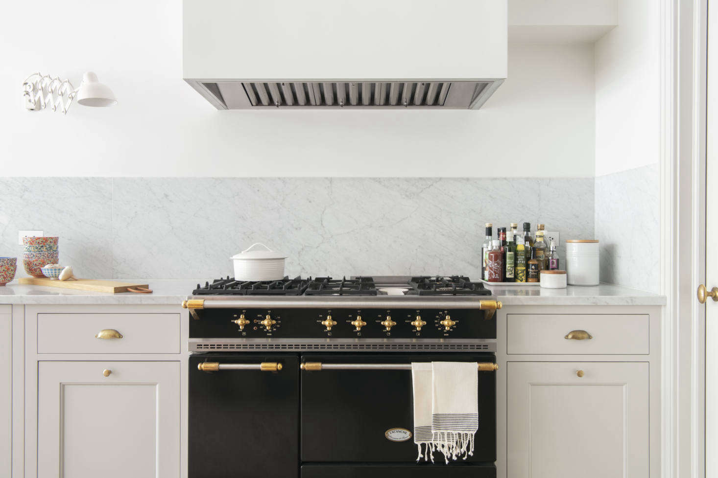 The range is La Canche’s Saulieu Classique in matte black. The pull-out cabinets on either side of it hold pots and pans.