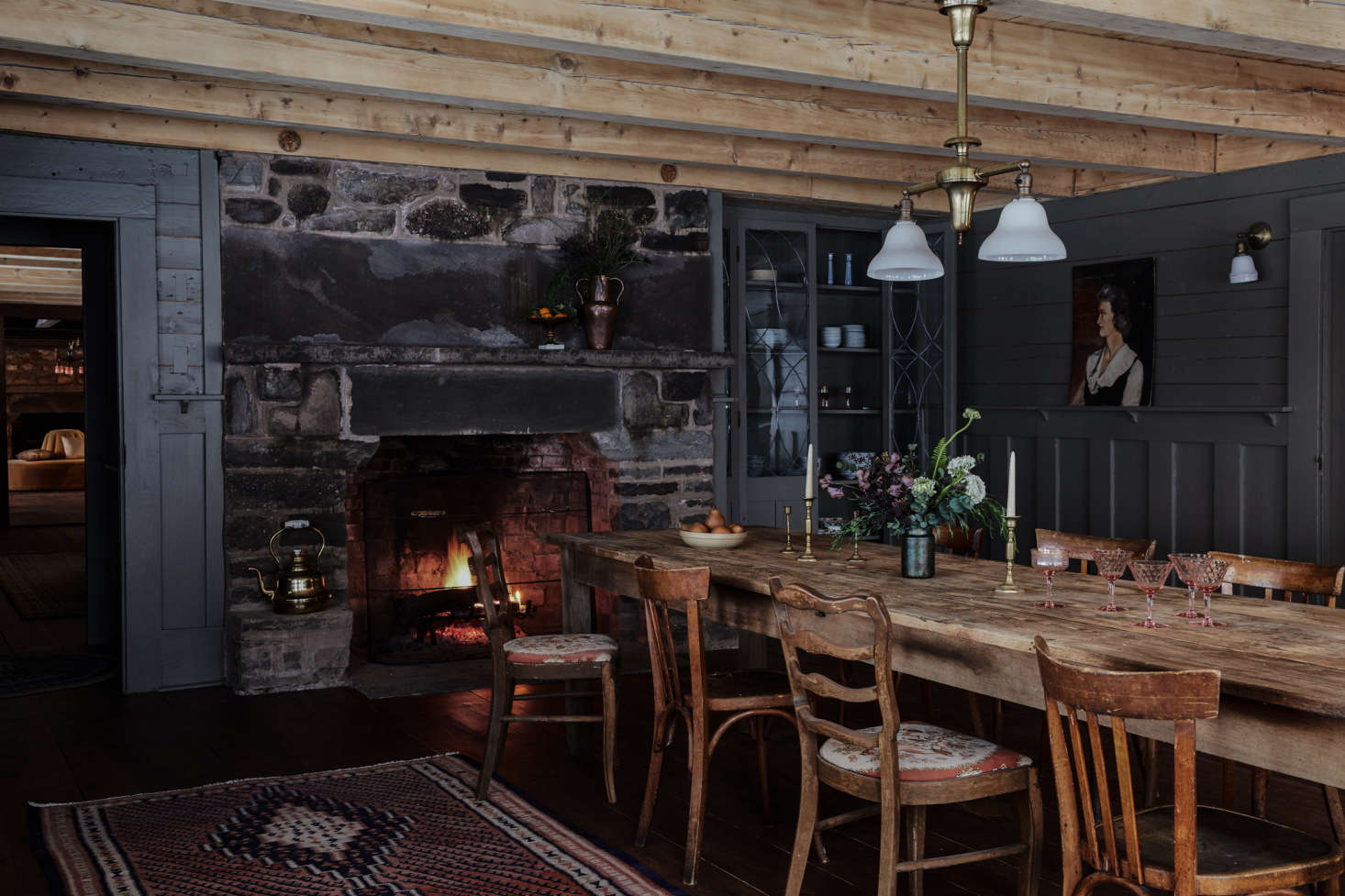 Surrounded by more original paneling, here painted Benjamin Moore Devonshire Green 89, the cozy dining room feels like a rustic tavern. The vintage farm table and chairs are another Brimfield find, while the antique light fixture is from Fed-On Lights in Saugerties, New York.