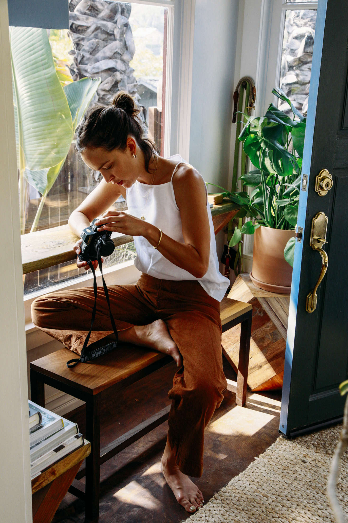 In the entryway, Jodi sits on a maple bench by Joinery. The space already had a shelf installed. Now, with the bench, the area can be used as a workspace, a place for putting on shoes, or extra seating for guests.