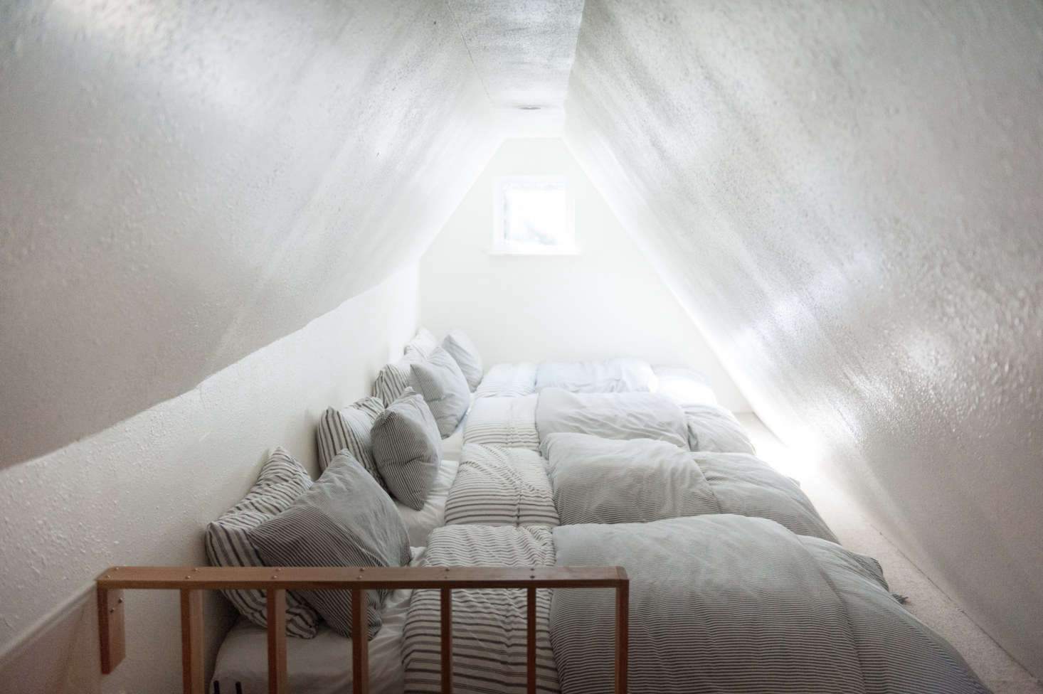 For visiting families, there’s just enough space for four twin mattresses in a row. The striped sheets and duvet covers are all from Ikea and include Nyponros duvet covers and pillowcases in charcoal.