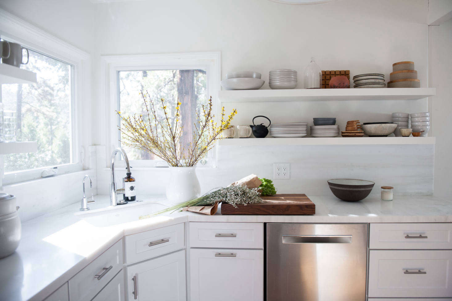 The counter and backsplash are Pentelico, a marble with subtle greenish veining: “It came polished and I had it honed, which feels more casual and better for the cabin,” says Lauren.