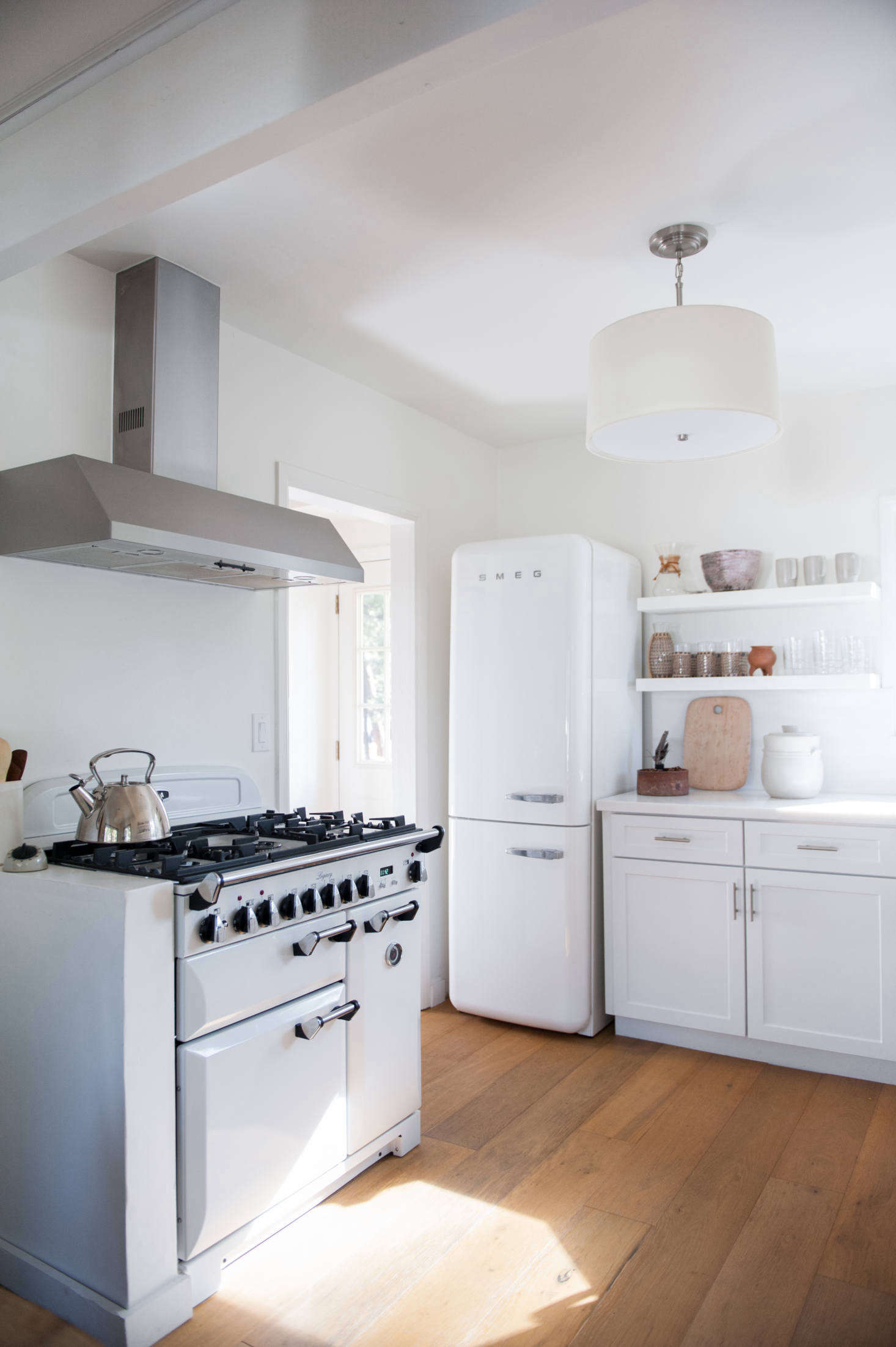 Wire-brushed, engineered wide-plank oak floorboards replaced the kitchen’s wood laminate (as well as the living room and bedroom’s wall-to-wall carpeting). The range is Aga’s Three Oven gas model.