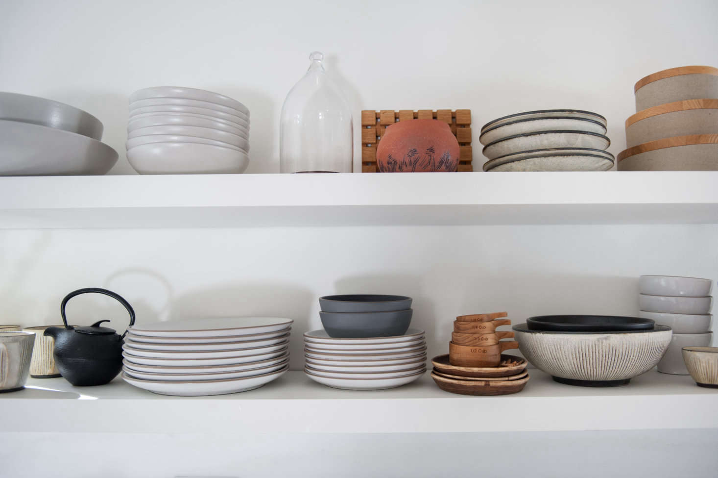 The shelves display plates from Heath and covered bowls by Hasami.
