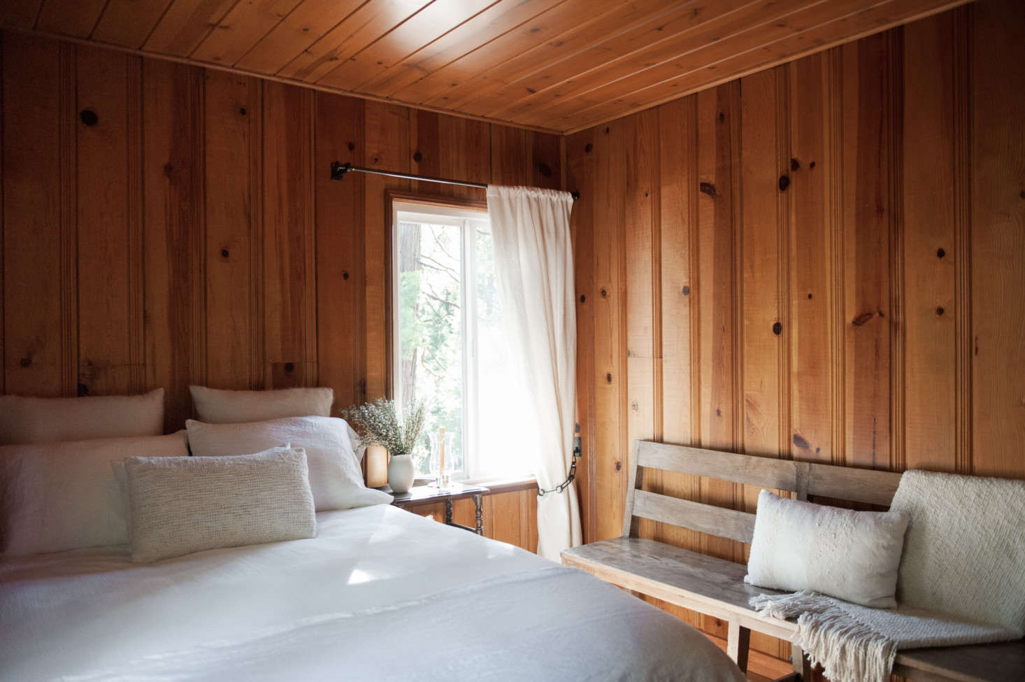 The paneling in the bedrooms was also left natural but sanded to mute its varnished finish. Shown here: the first floor guest room.