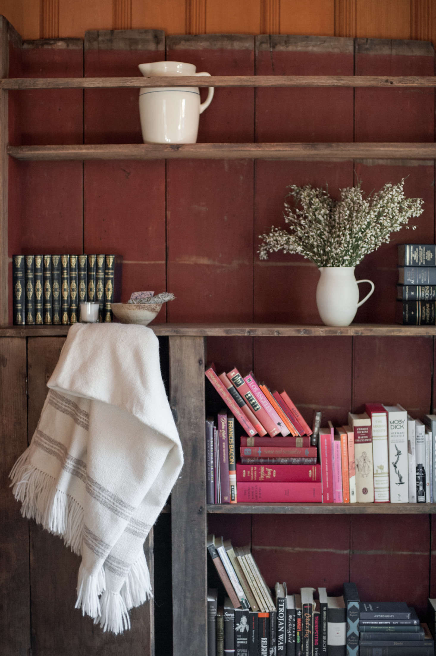 In the guest room, a painted bookcase found at Brenda Antin Antiques holds Leanne’s late mother’s books.