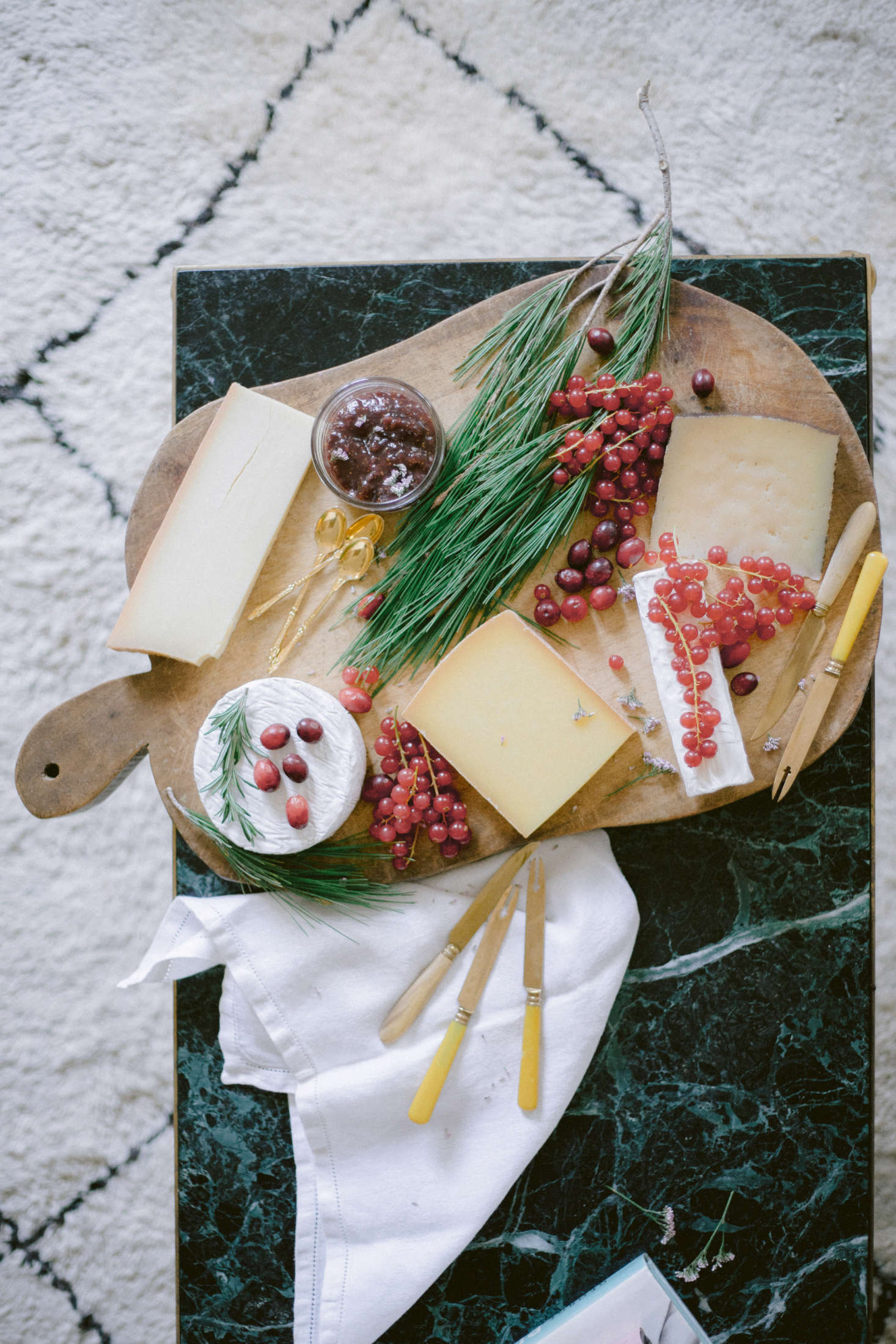 Tiny pink berries and greens add liveliness to the cheese board.