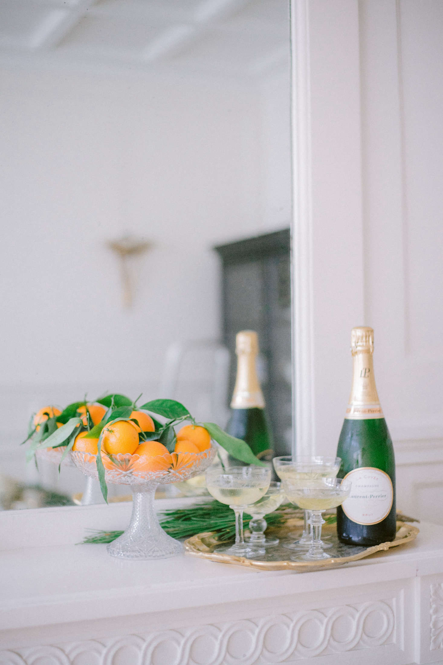 Vintage champagne coupes from Aki’s collection are ready for the taking on the mantel.