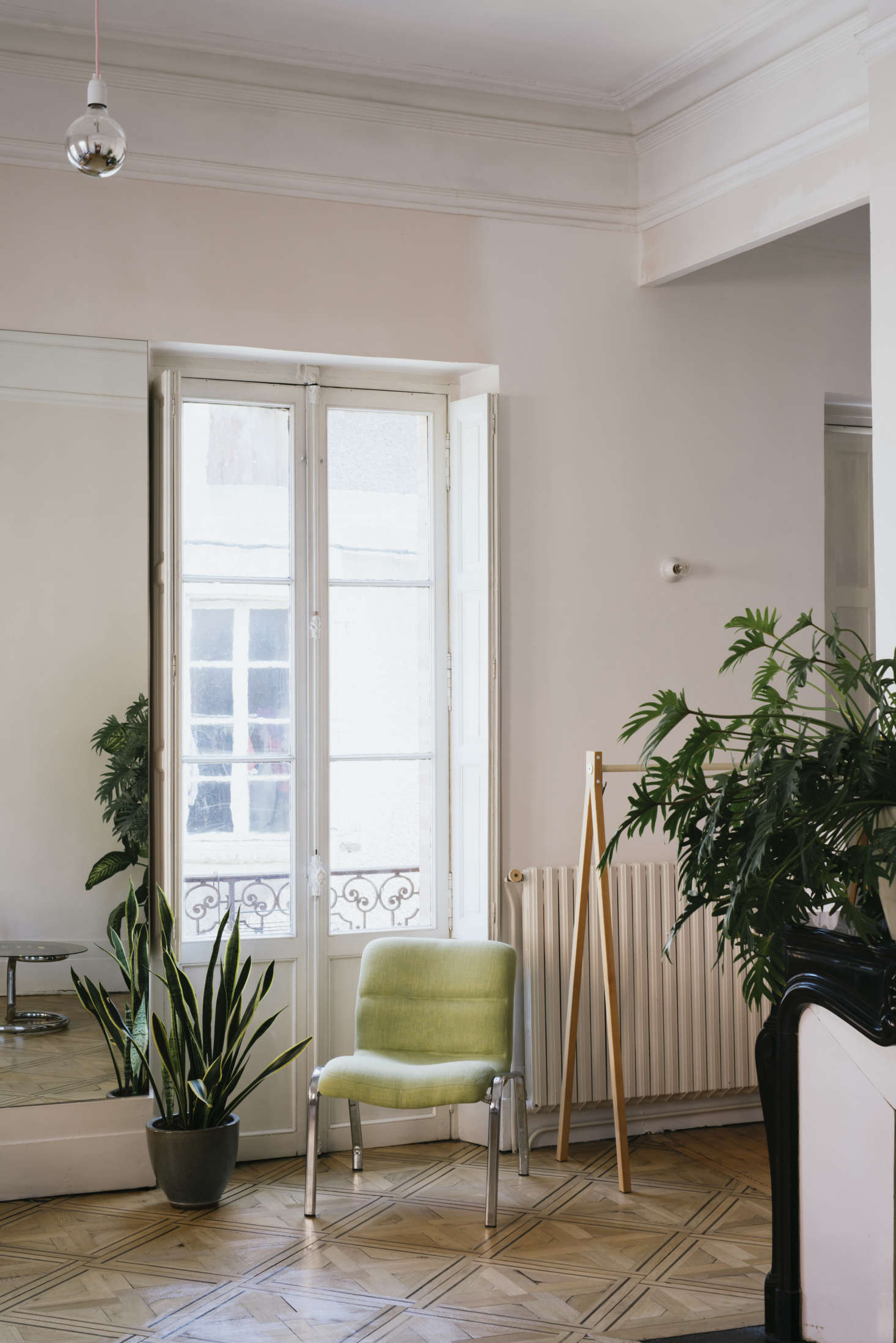 Sathal’s addition of mirrored panels in just a few rooms throughout the house adds, as she says, “life, movement, relief, light, even more depth.” She also opted for silver-tipped lightbulbs throughout, as in this deconstructed pendant light: “I don’t like too-bright light,” she says.