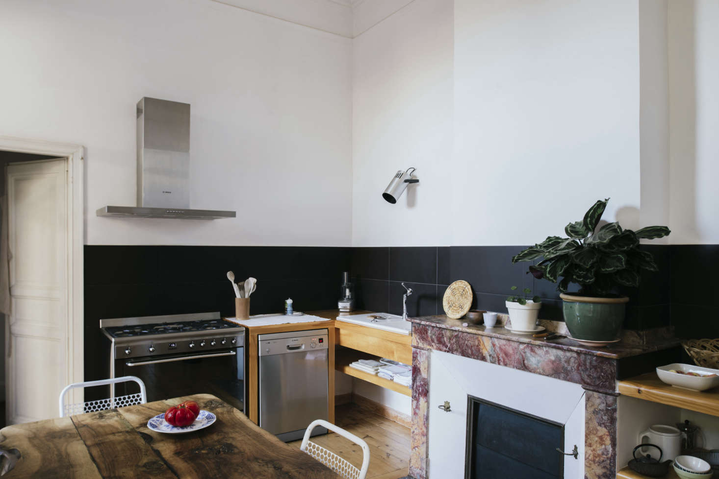 Sathal designed the simply fitted kitchen around the mantel. “I wanted all the pretty things in the kitchen to be visible, and I wanted a big work plan,” she says. She designed built-in shelves to serve as counters on either side, integrating the mantel in the center. “The shelves were built by a carpenter known to my father in Marseille,” she says. “I took very precise measurements and made a plan and he realized them. They were brought back in a truck and the workers put them in.”