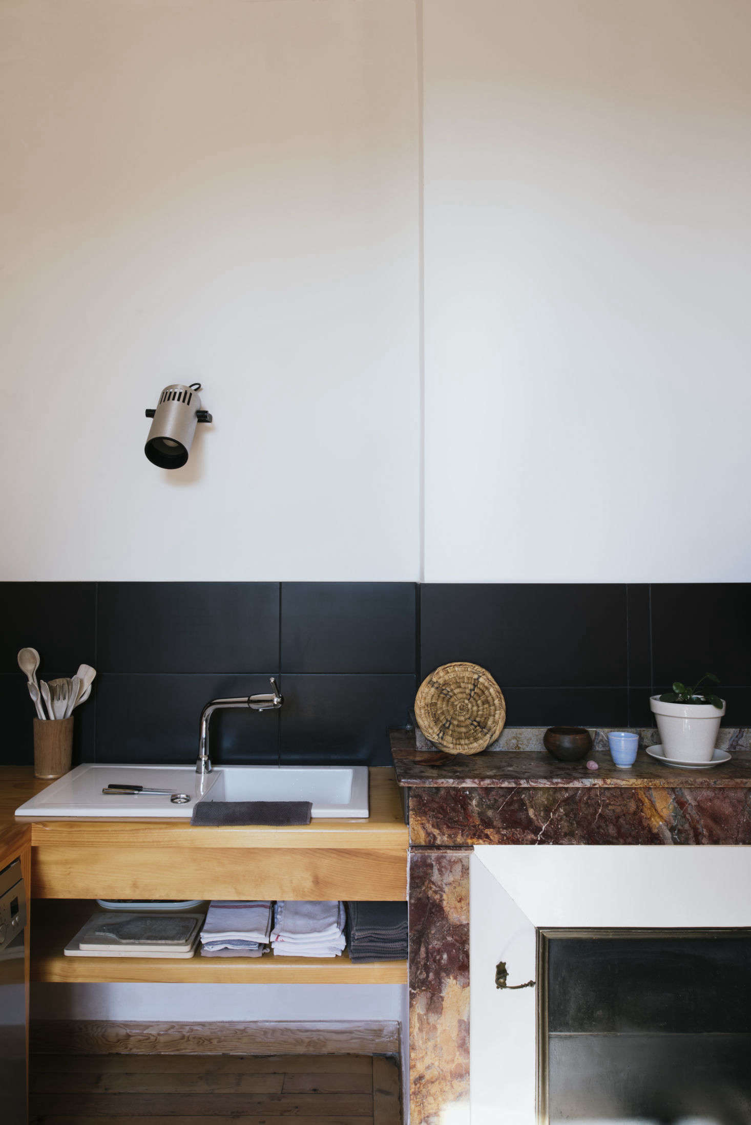 A sink, fitted into a wooden counter. Above it is an old projector light, a nod to Sathal’s work in film.