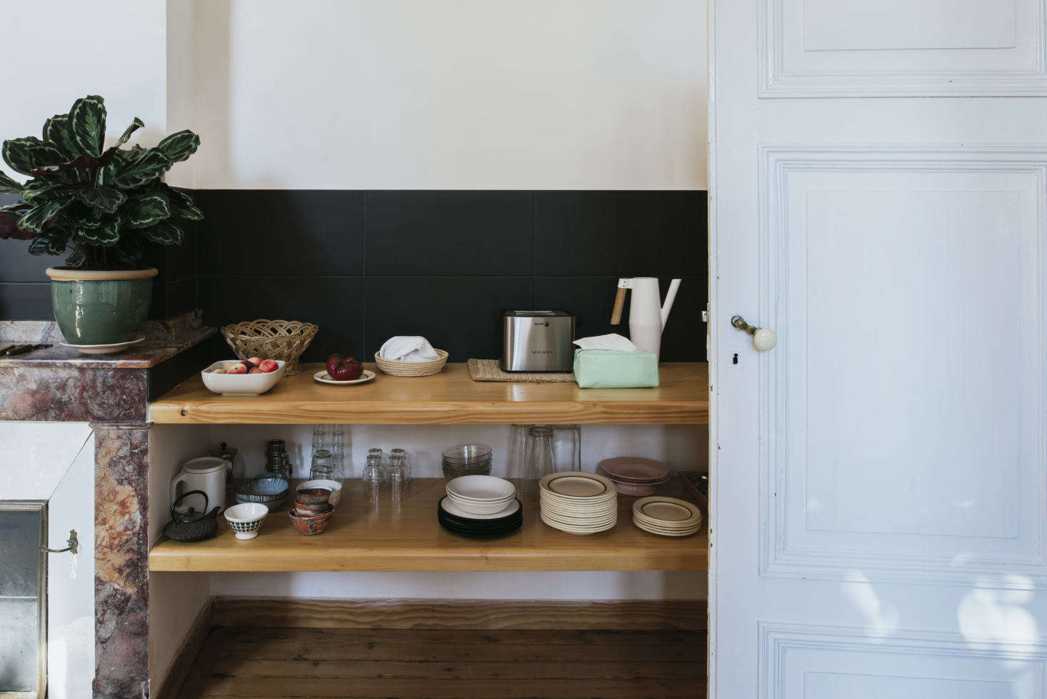On display are Sathal’s collections. “These are dishes that I find mostly in flea markets, and when my boyfriend travels, he brings me back finds from different countries,” she says. “I find tea towels in the vide-greniers and I also make linens.” The low black backsplash is made of Italian tiles.