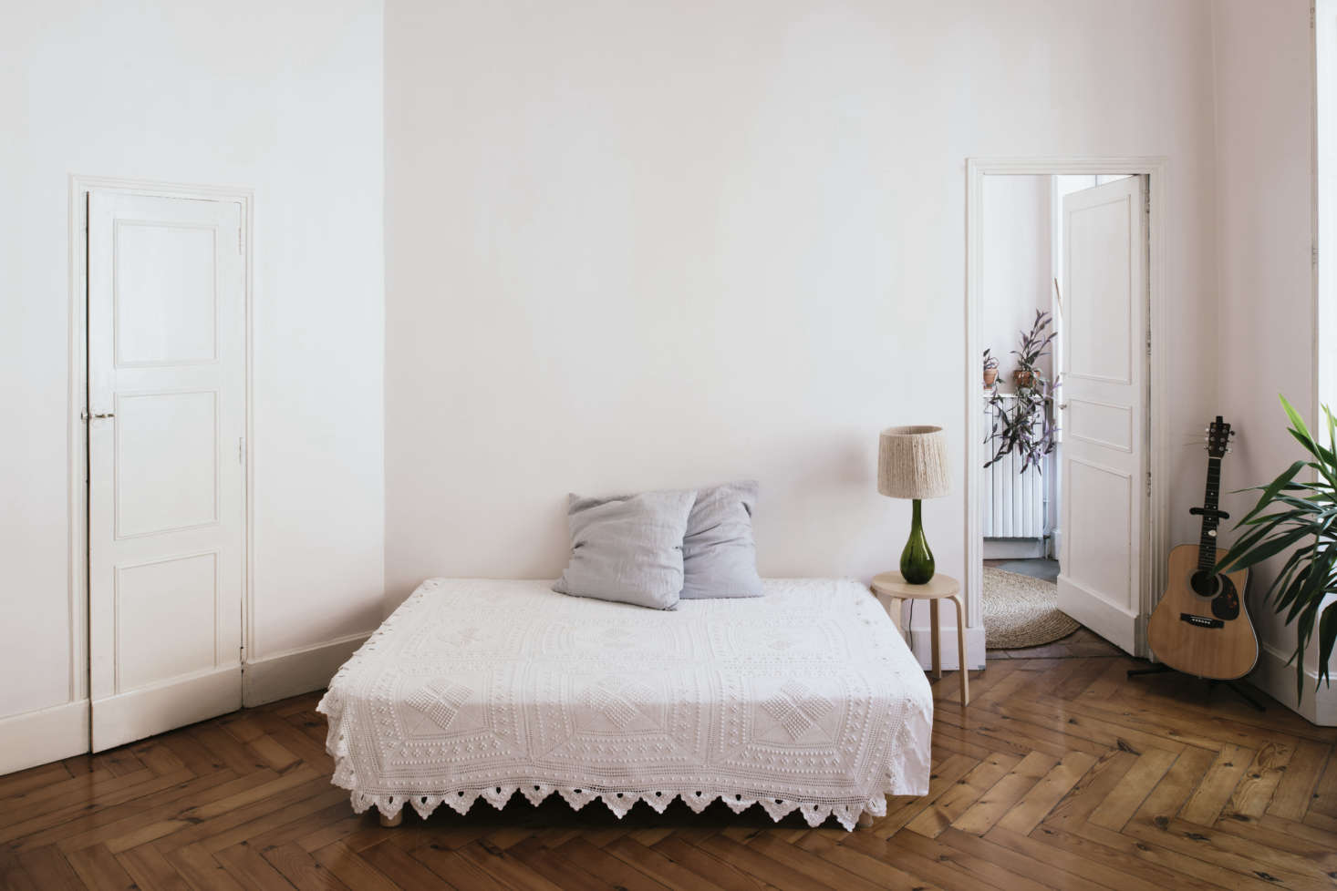 The sparsely fitted bedroom. “This room and Kélit’s room are a continuation of the living room with the white sofa,” Sathal says. She found the torn crocheted blanket at a flea market and repaired it herself.