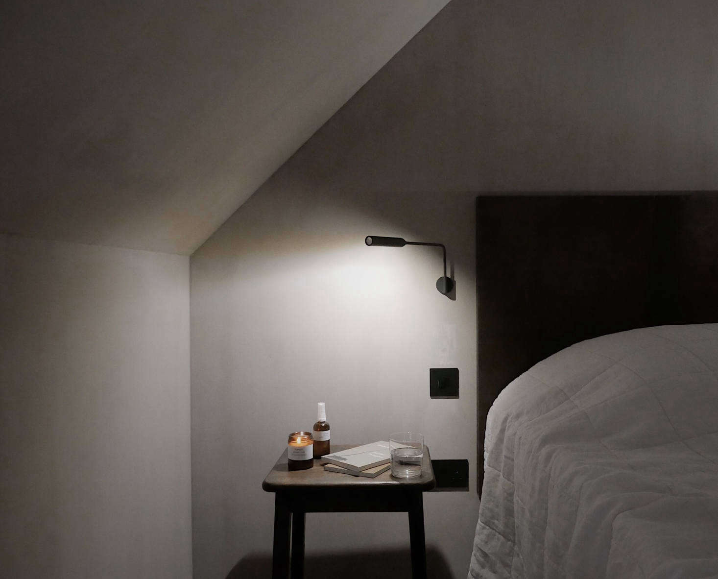 The beds have custom leather headboards and bedside Flo LED Wall Lights by Foster & Partners. On the side tables: reading materials as well as naturally scented candles and “comfort mists” by UK company Honest.