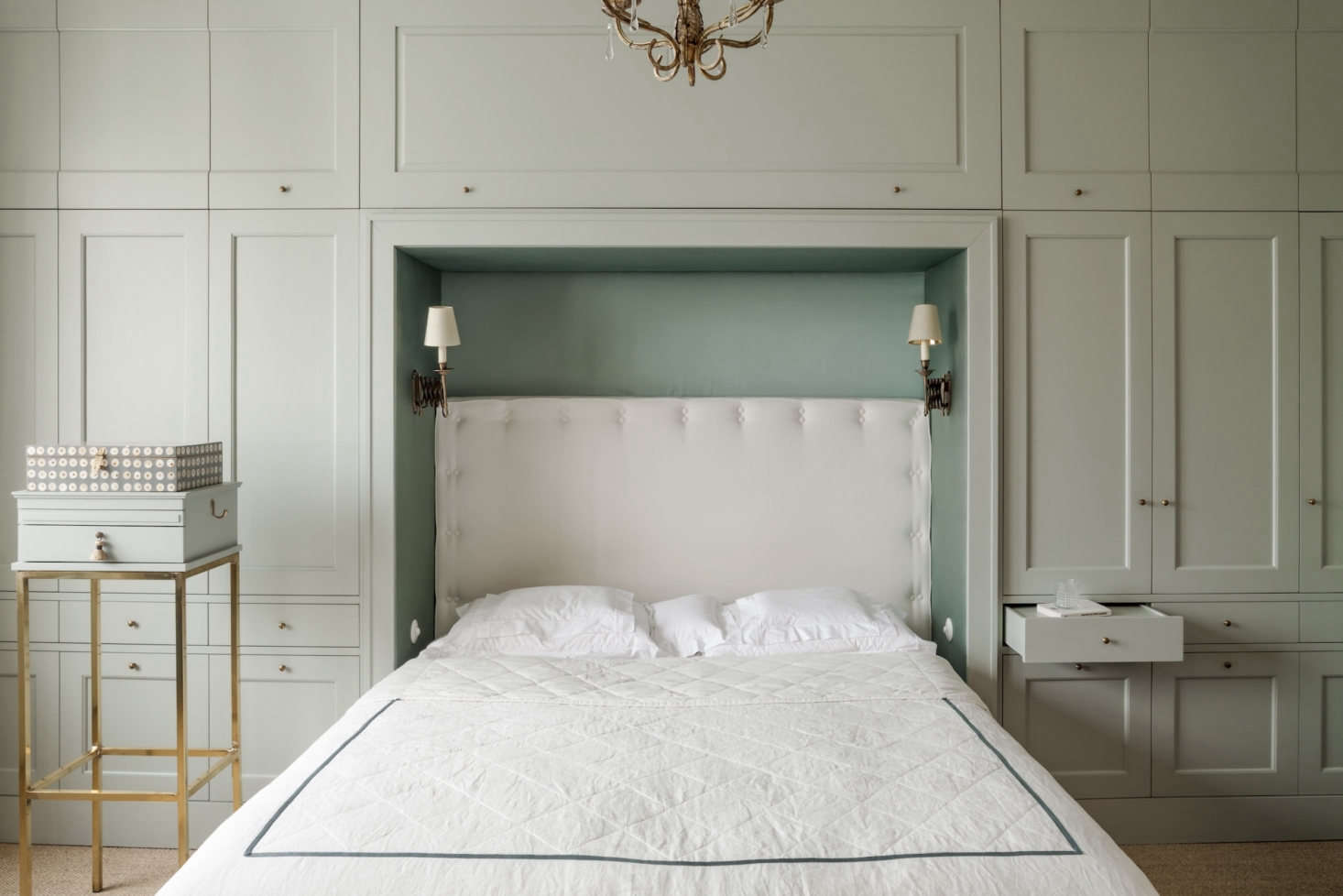 To add much-needed storage in the bedroom, Chrapka designed a wall of built-ins, painted in Farrow & Ball’s Light Blue. The antique sconces are from eBay.