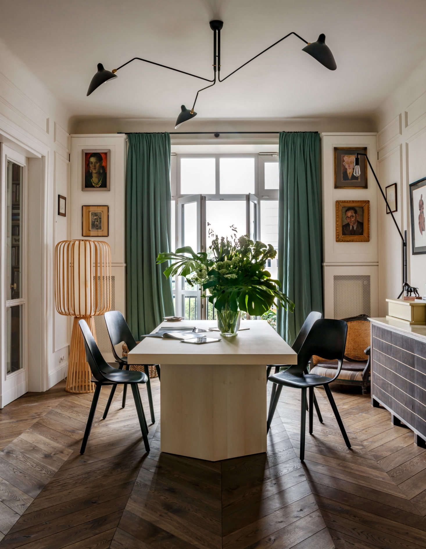 Floor-to-ceiling drapes were made from Fadini Borghi linen by Pierre Frey, the iconic French maker of fabrics and wall coverings. Green is the owner’s favorite color and shows up throughout the home. A modern ceiling light by Serge Mouilles hangs above the table; the sculptural floor lamp (left) was an eBay score.