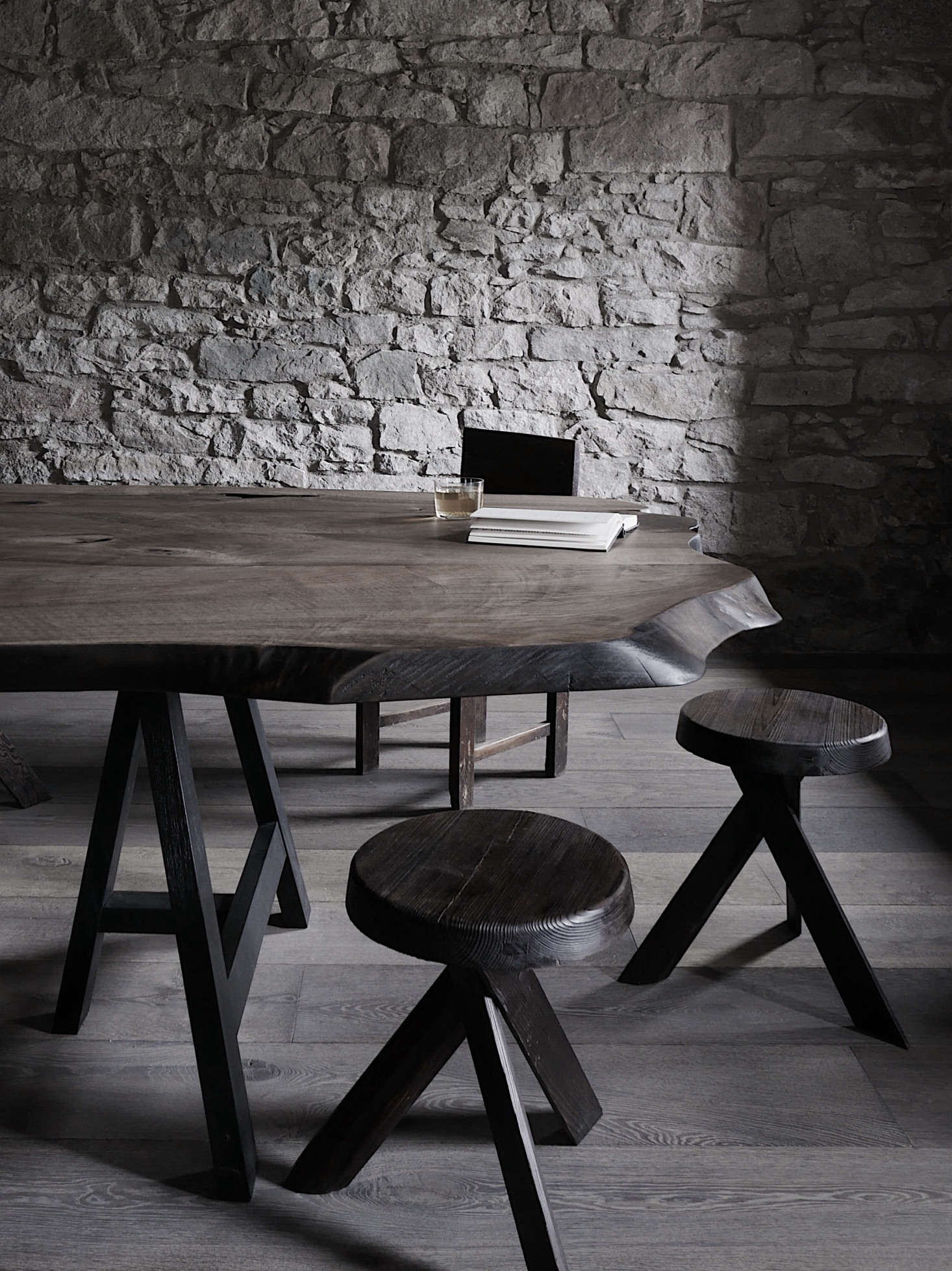 The dining room’s 13-foot table was designed by Van Reeth and custom made by Heerenhuis of Antwerp. It’s surrounded by vintage chairs and Pierre Chapo stools. The stone walls are all original.