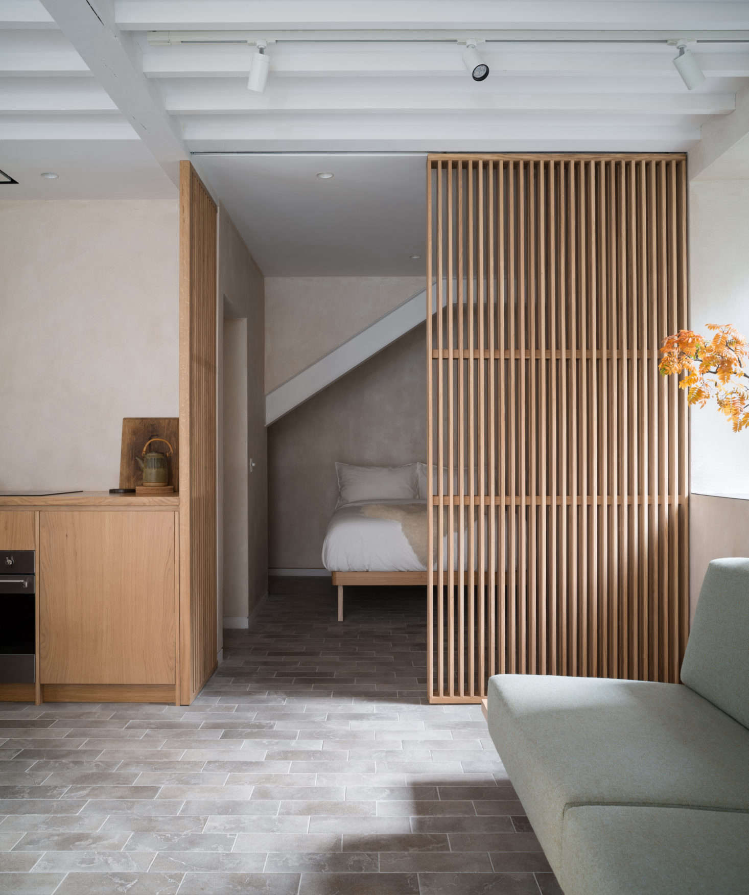 The lines of the screens, the stone tiling, and exposed rafters lend the design the tidiness of a Rubik
