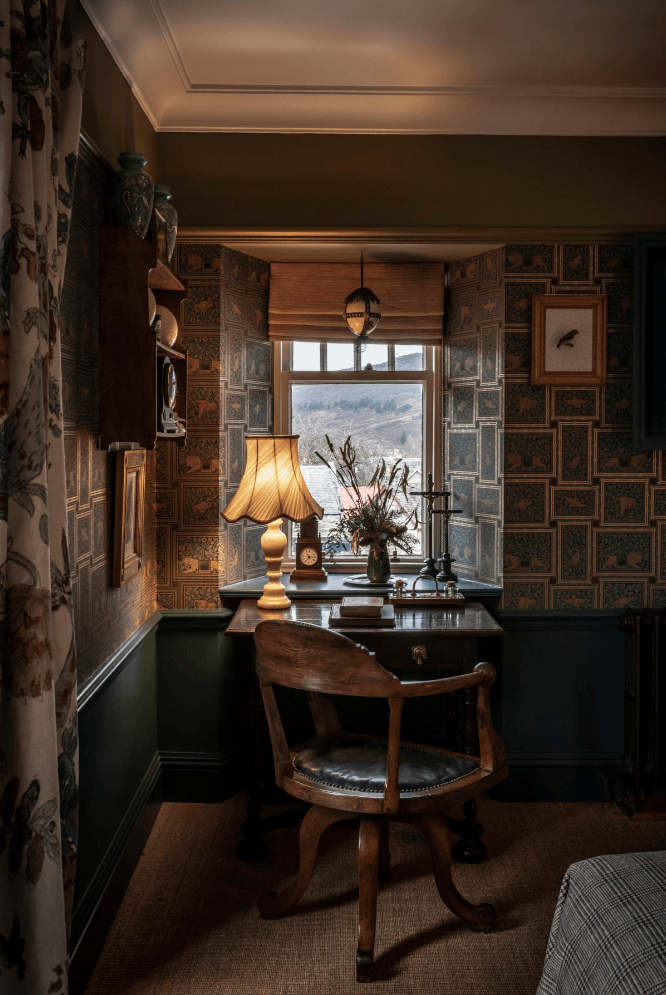 A vintage desk looks out at the countryside in another room.