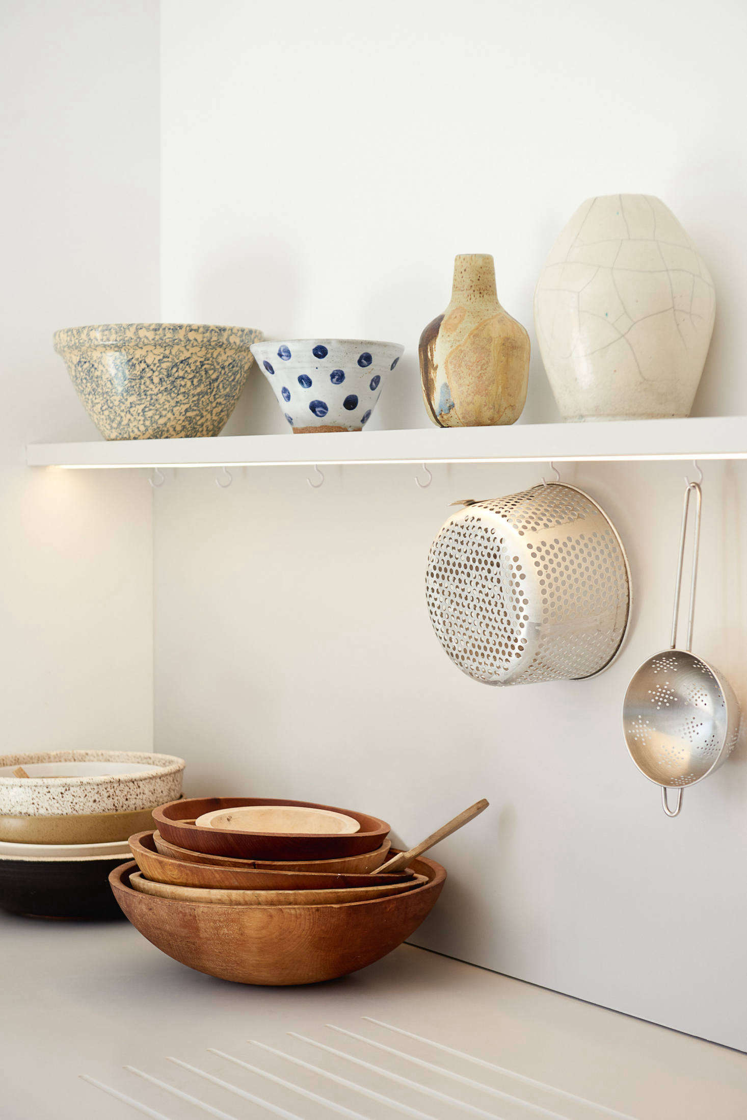 Simple hooks under the open shelf provide hanging storage.