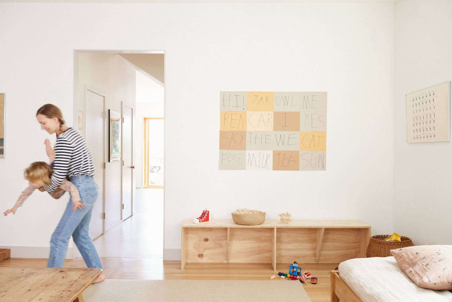 Lena wrangles her 4-year-old, Abe. The artwork above the custom plywood bench by Jay Nelson was a project she did with her 8-year-old, Eli: 