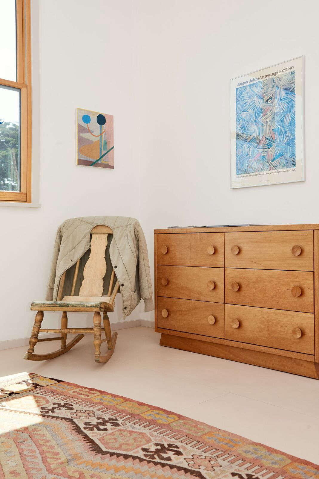 A rocking chair from a family friend and a vintage dresser occupy a corner of the master bedroom.