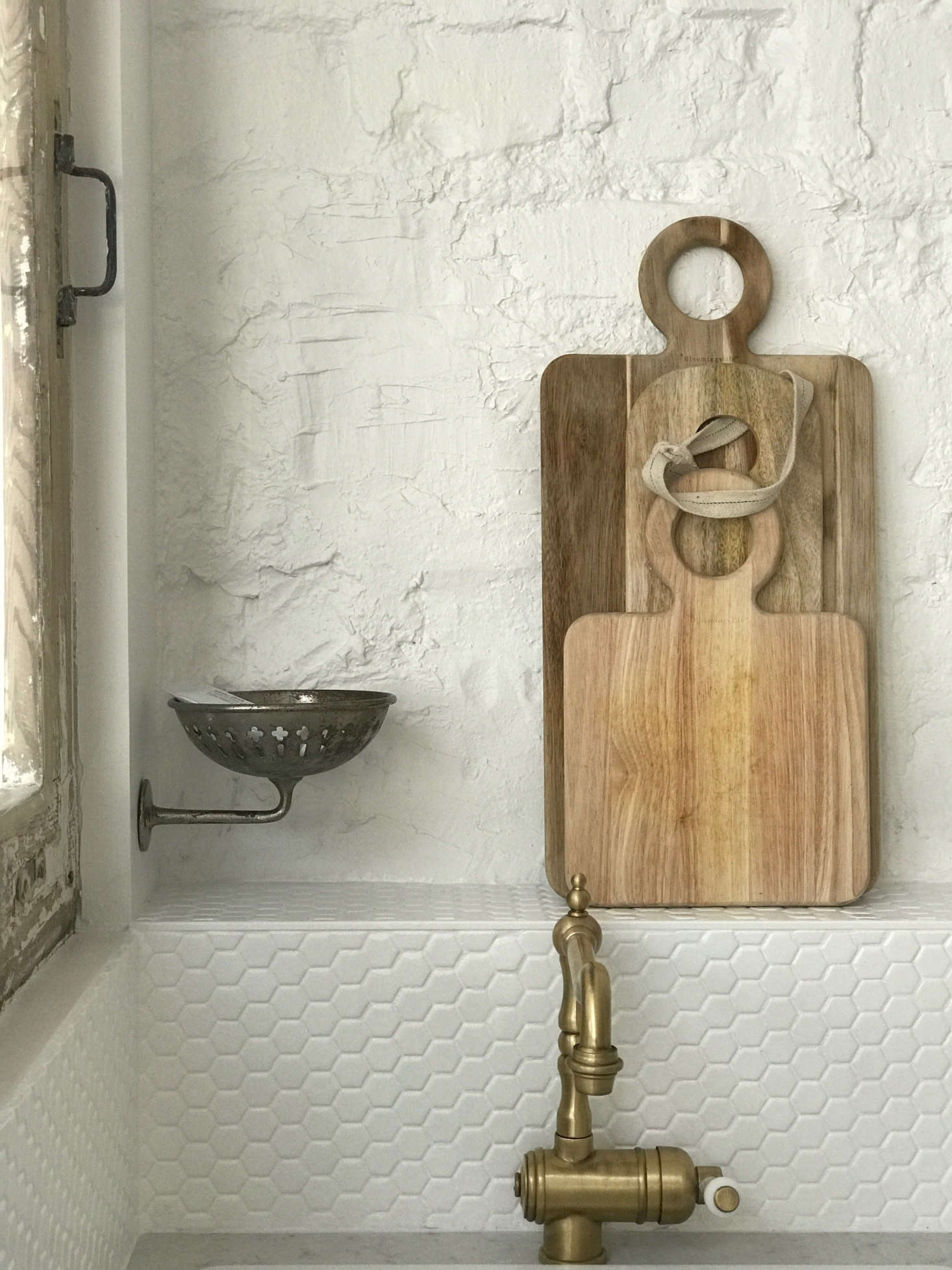 The hex-tiled ledge backsplash comes in handy for displaying and storing.