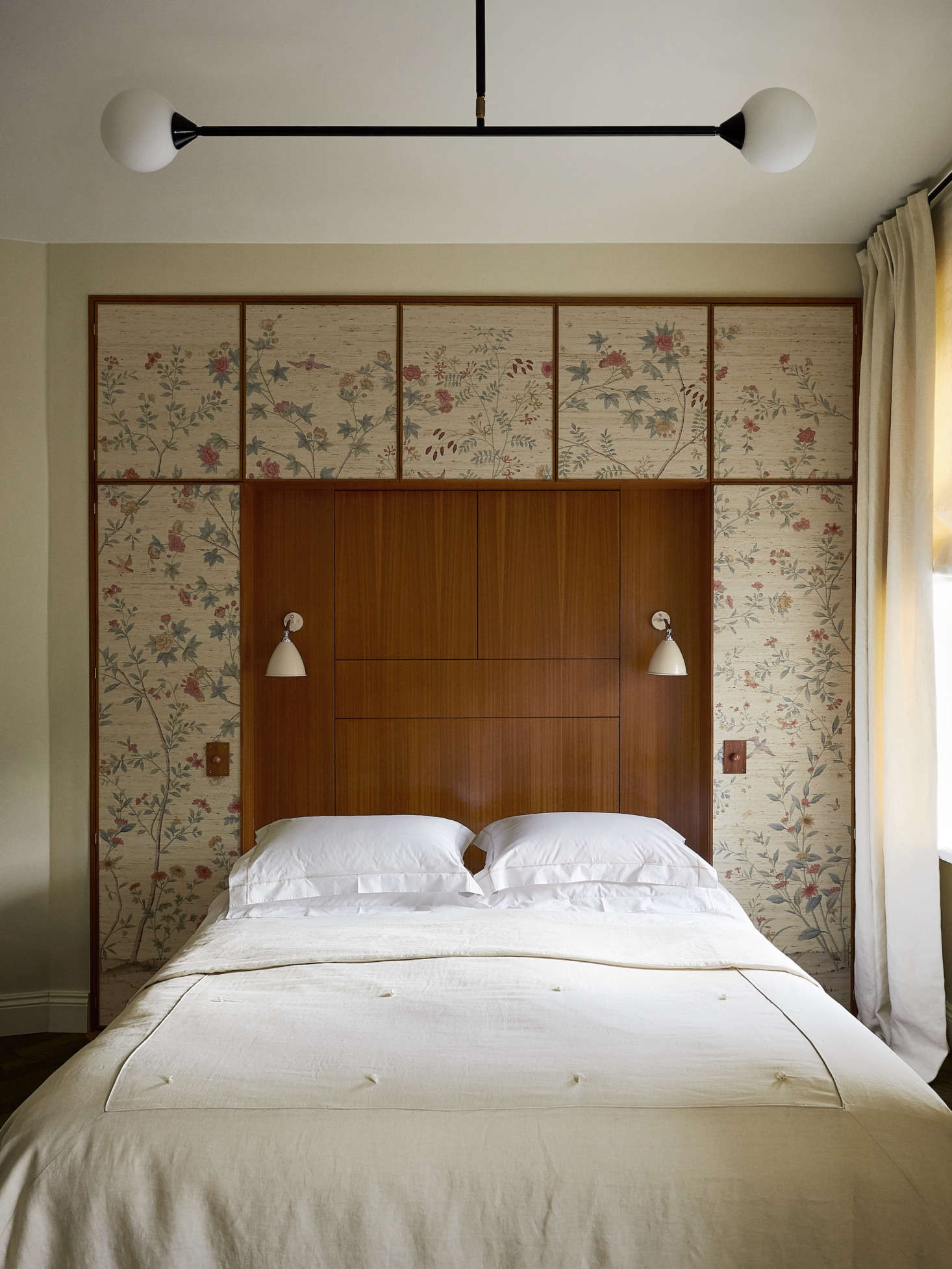 A quirk of the apartment is that nearly every room has a diagonal wall. In the bedroom, Chrapka straightened the room with the help of a built-in headboard and cabinet, covered with William Morris wallpaper. The Bestlite sconces are by Gubi.