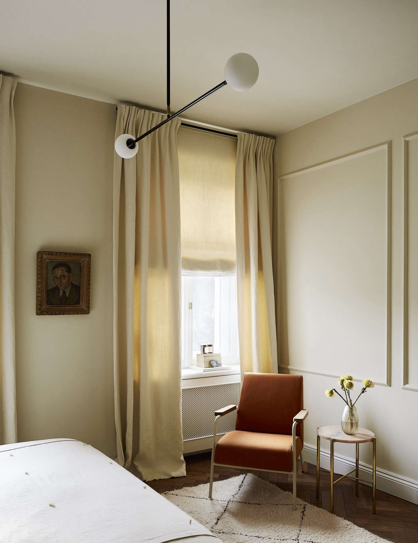 The Two Spheres pendant light from Atelier Areti hovers over the room, which is painted Alabaster, by Emente.