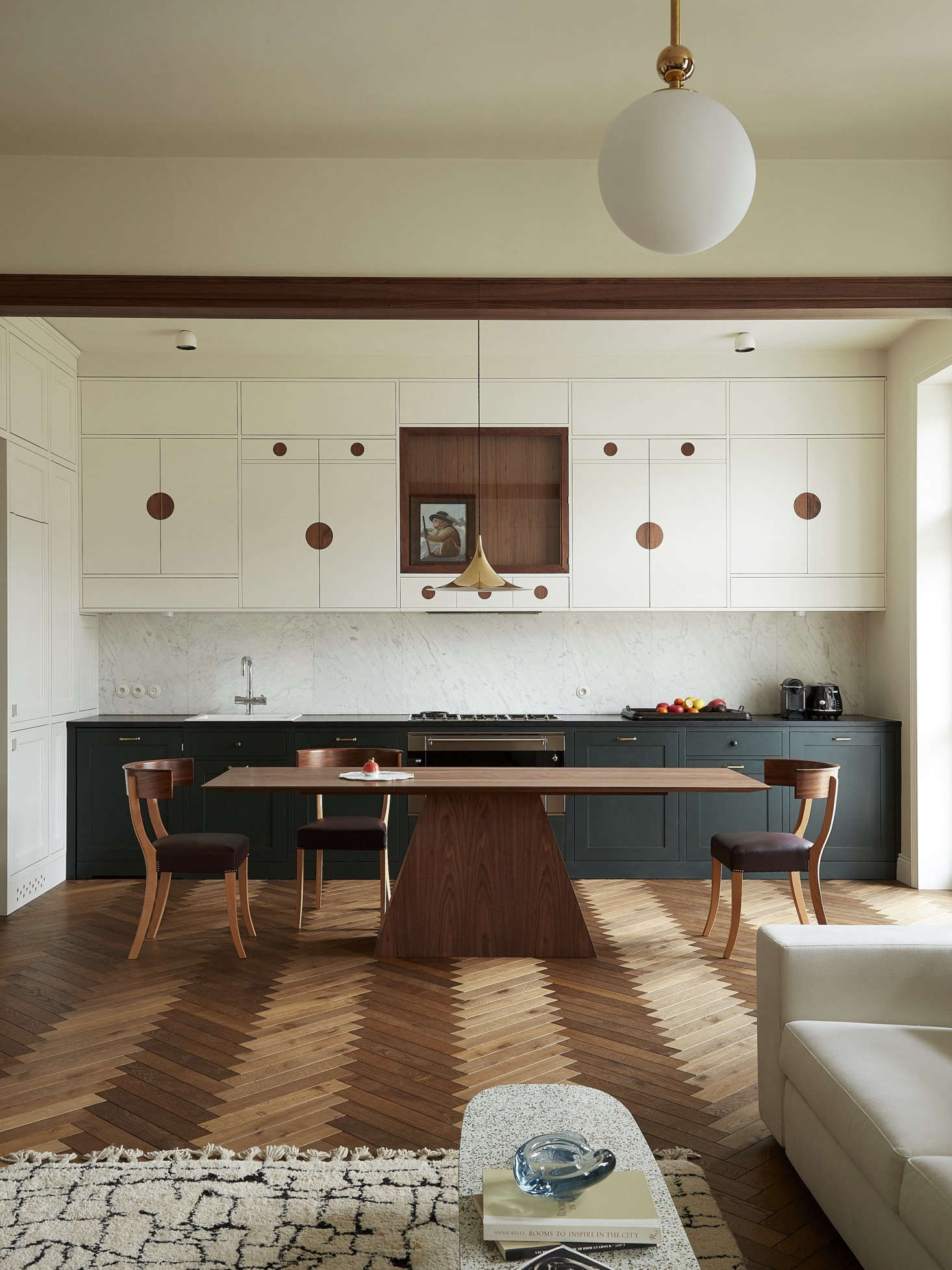The kitchen, open to the living room, was inspired by a Josef Frank-designed sideboard featuring walnut discs and glass doors. 