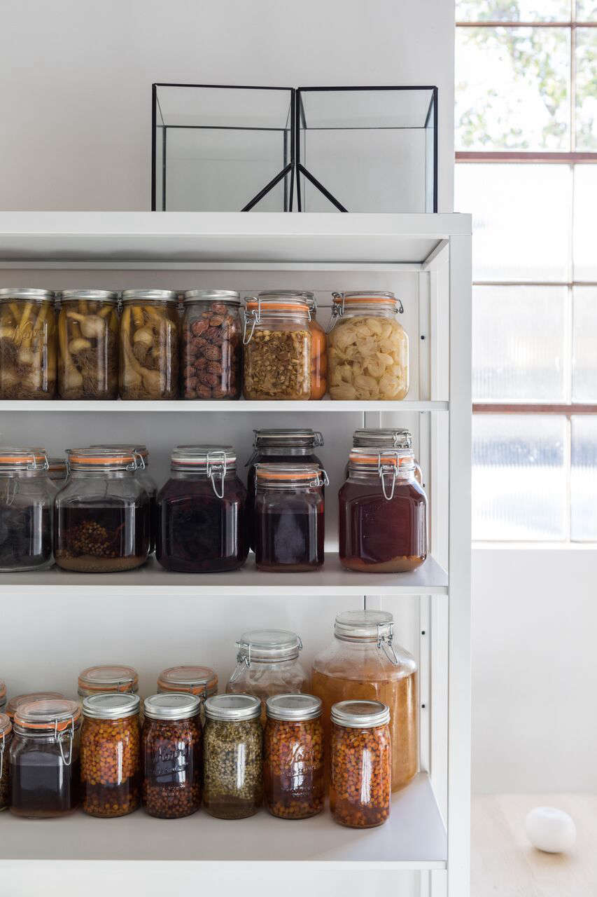 Mason jars filled with preserved botanical ingredients add a dash of color to the otherwise neutral interiors.