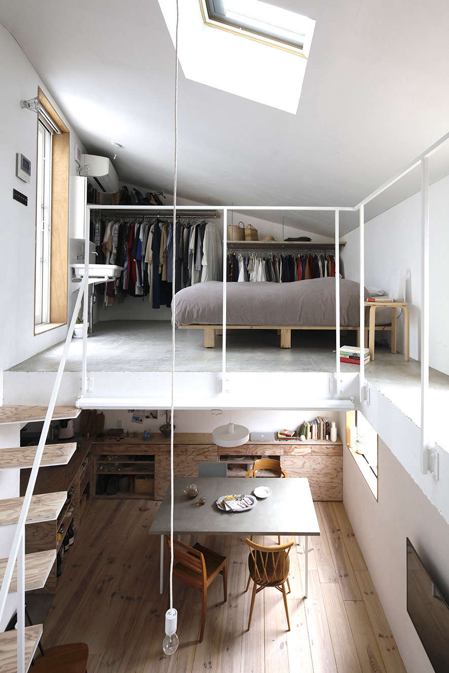 Edged by only a hint of railing, the master bedroom has open closets and a sink. It
