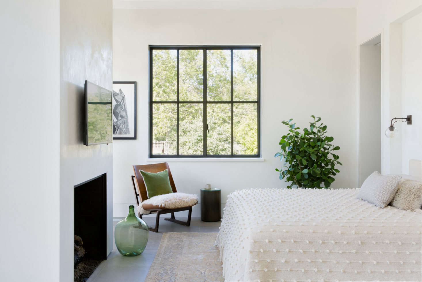 The master bedroom has a subtle palette of greens. The pom-pom coverlet is the Palomita Blanket found at Anyon Design (it