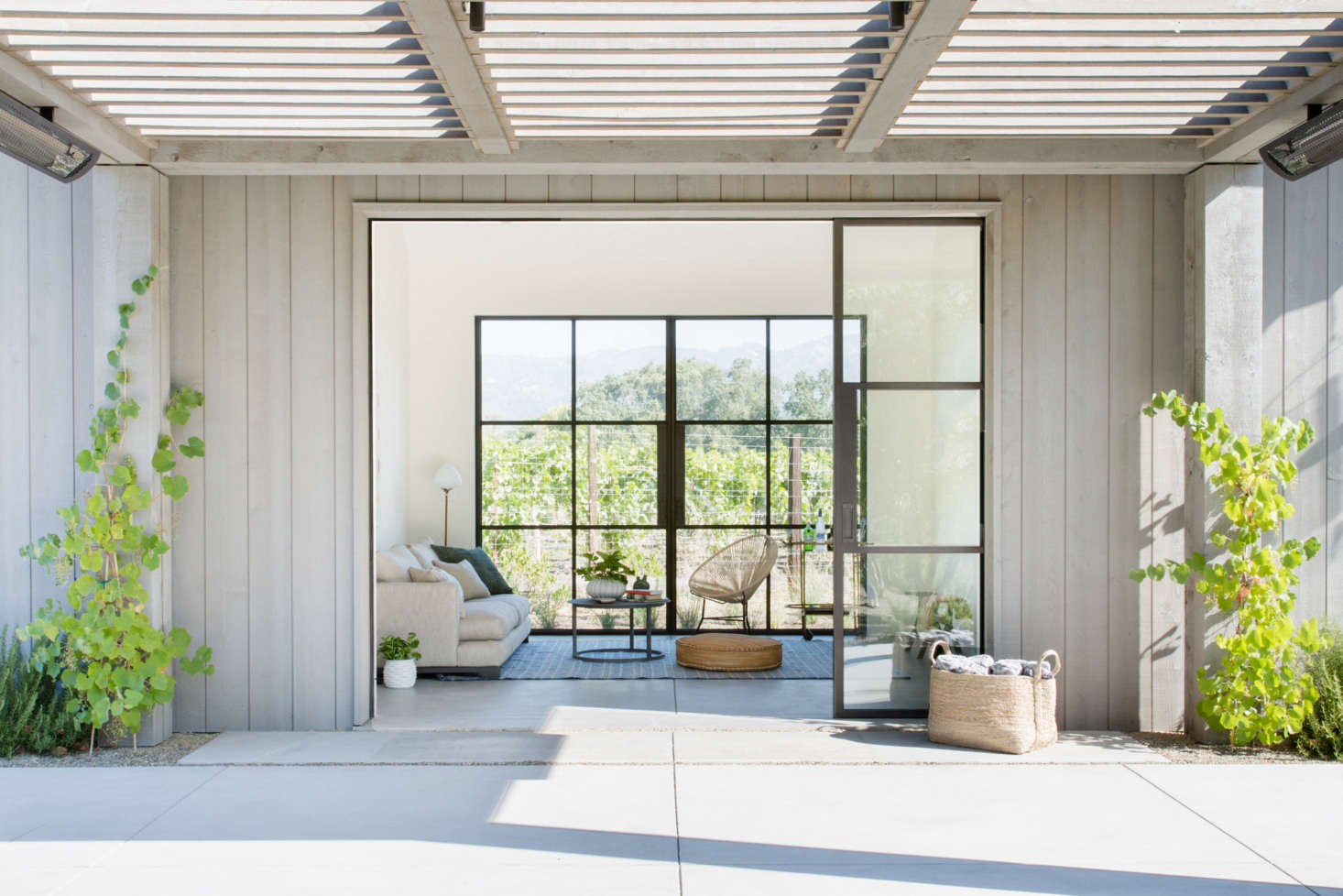 One of many living areas that opens seamlessly onto the grounds, thanks to steel-frame windows and doors by Jada Windows, and flooring—complete with radiant heating—that continues from indoors to out. The interiors are painted in Benjamin Moore