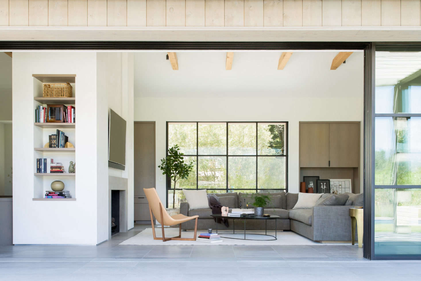 Another living area with low-slung furniture and natural wood beams. 