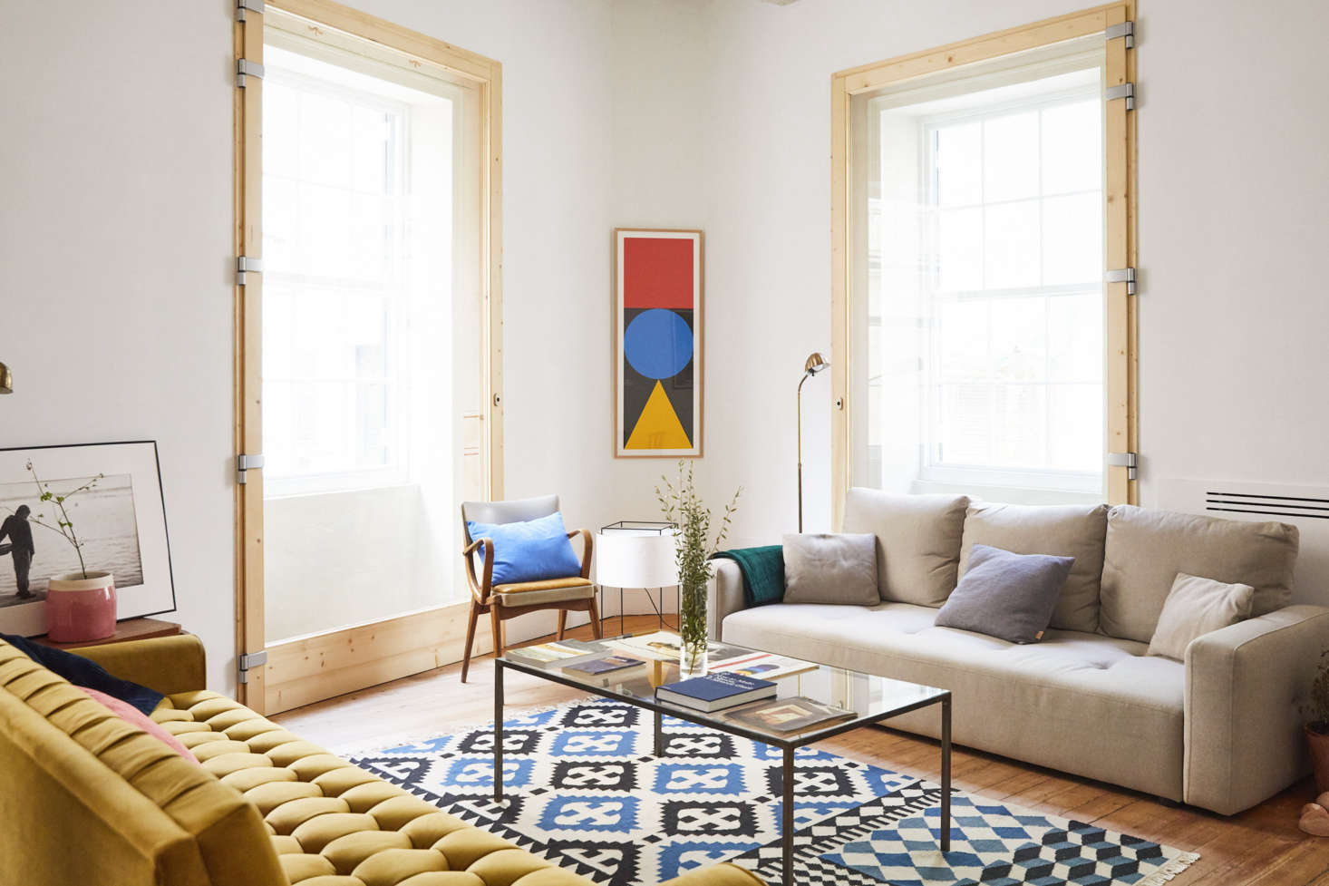 The hotel lobby area is equipped with more eclectic new and vintage furniture. The beige sofa is a new design, from Aquitania, a local shop in Maó, the rug is from Gan Rugs, and on the wall is a poster from the Musée des Arts et Métiers in Paris.