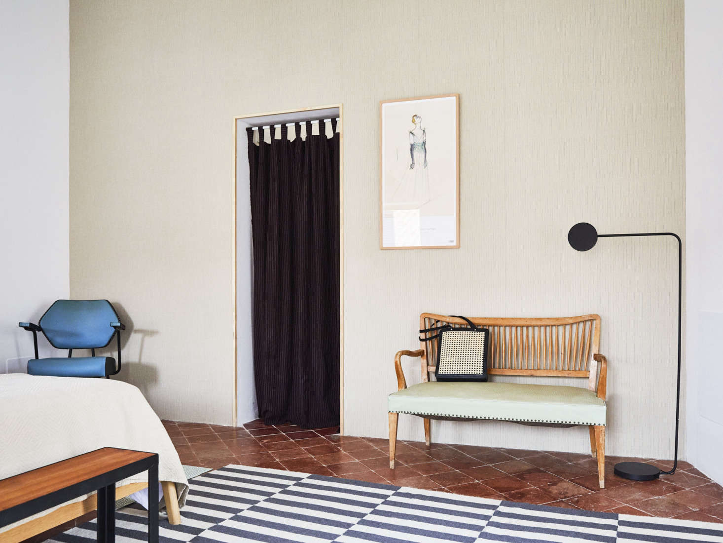 In another room, a single wall is wallpapered with the Waverly Kids Highwire Stripe pattern from Aribau. The bench, a Catalan modernist piece, was sourced a vintage antique dealers show, and the rug is simply the Ikea Stockholm Rug.