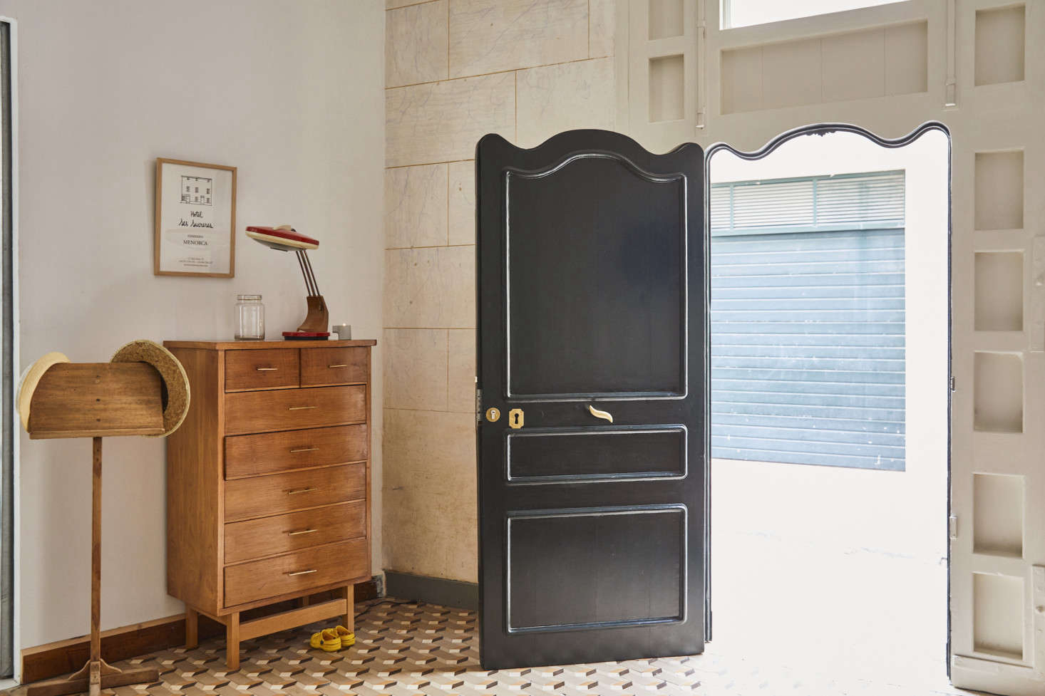 The undulating door and door frame design is original to the building, painted in the original black-green color that locals call “the green of Maó.”