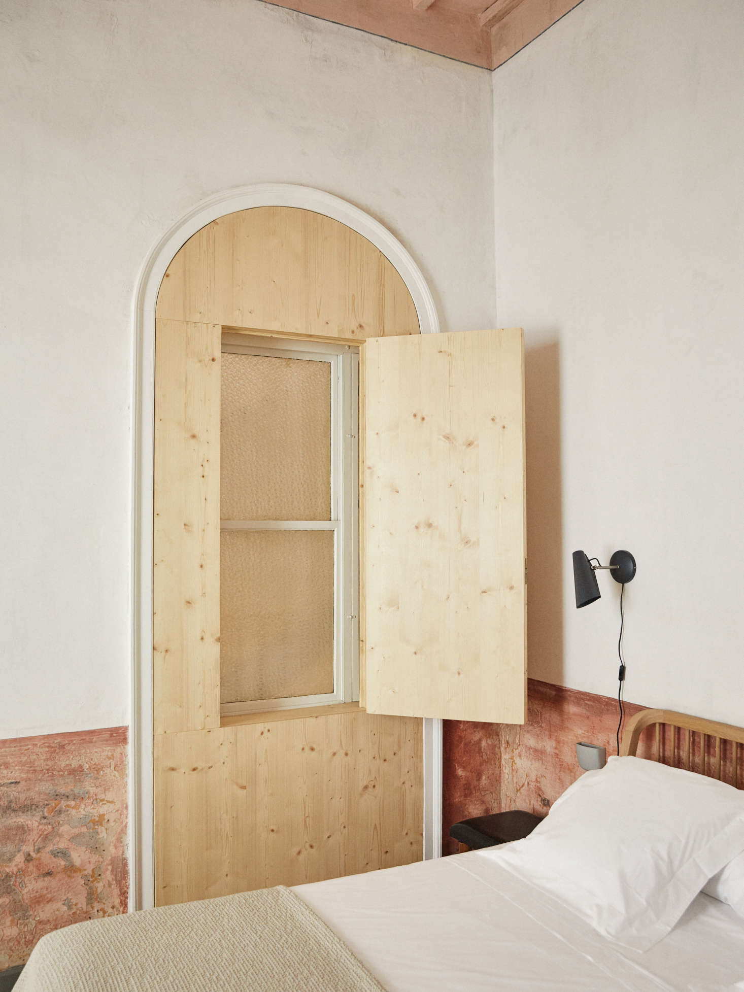 The window situated within the old door frame was designed by Martí to create a “false order of things,” as Ignasi says, along with insulating for sound.