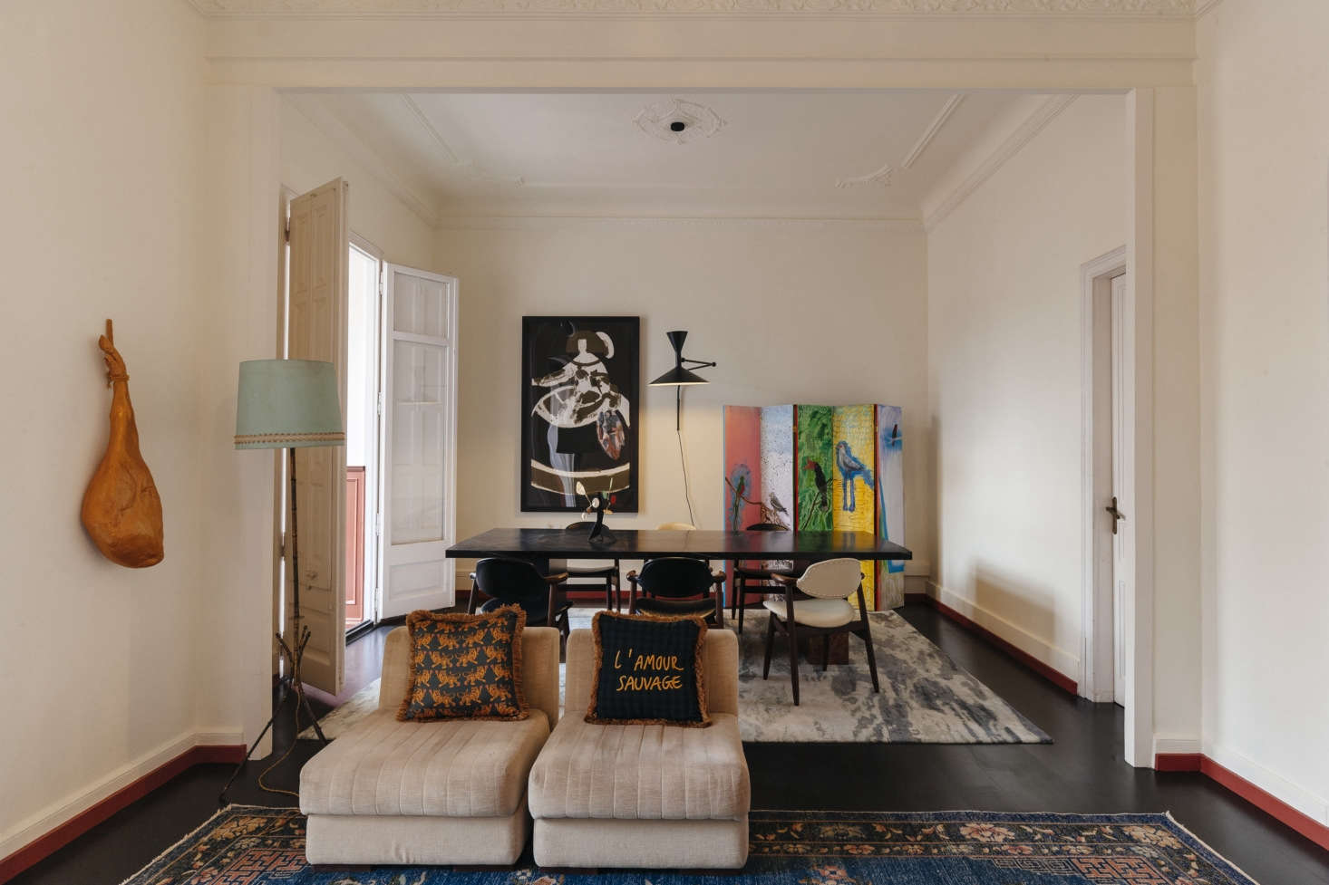 The other half of the room has a sitting area, a dining table/meeting space, and a sculptural faux ham on the wall. The baseboards are trimmed in the same brick color that’s used on the wainscot in the adjacent sun room.