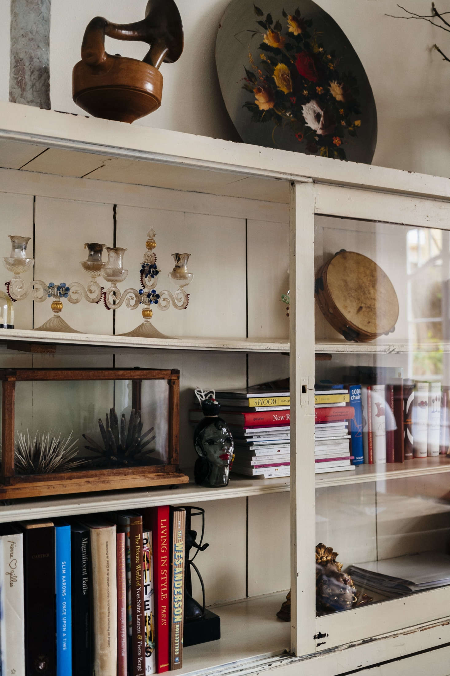 Design books and magazines are surrounded by some of the duo’s latest finds, including a pair of Venetian glass candelabra and a Wardian-style terrarium case.