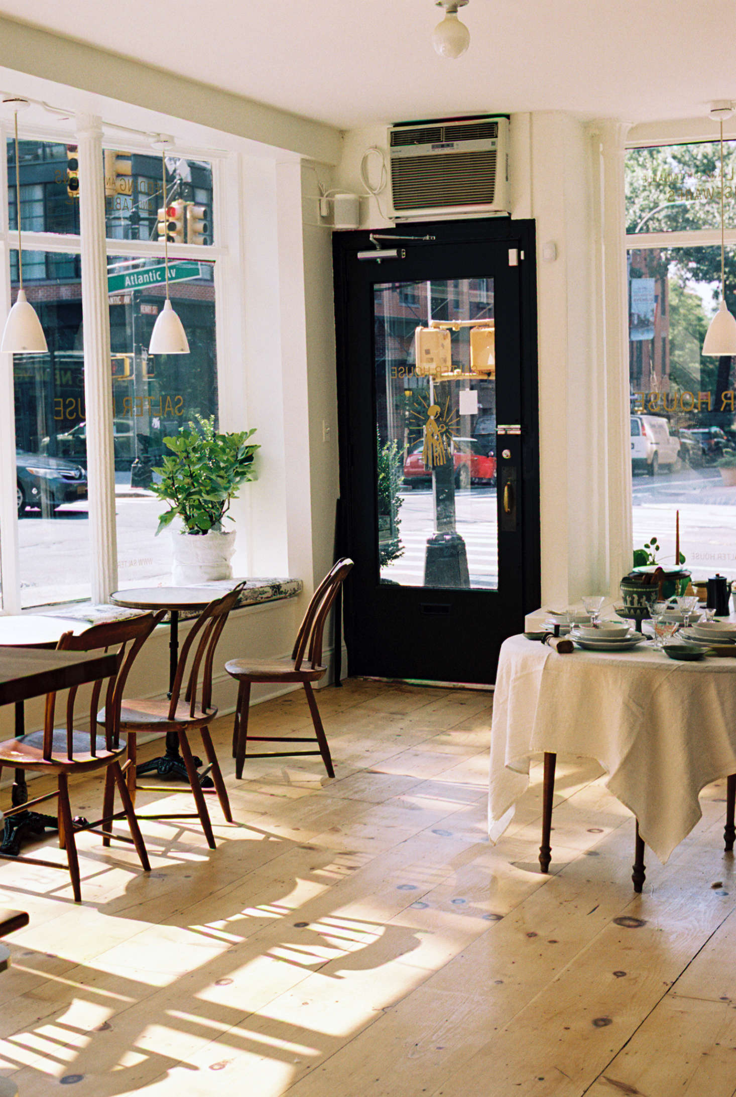 Inside the shop, with wide-plank wood floors and plenty of southern light.